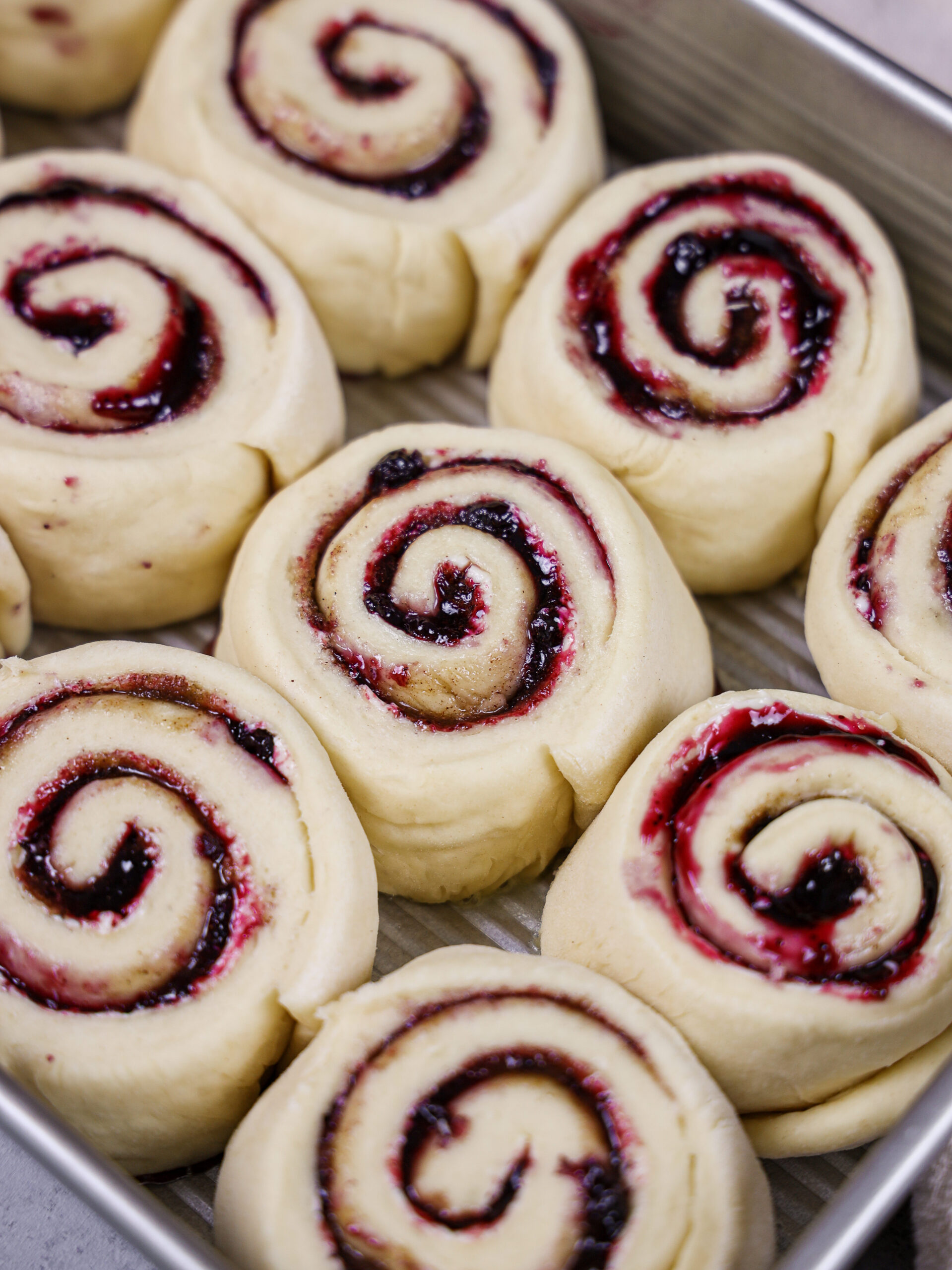 image of blueberry cinnamon rolls that have been cut and proofed, and are ready to be baked
