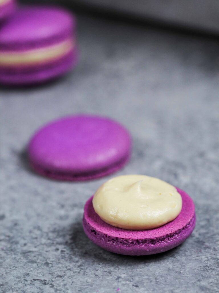 image of a purple macaron shell filled with a honey lavender buttercream to make honey lavender macarons