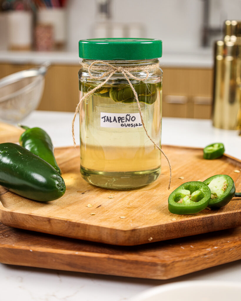 image of a jar of jalapeno simple syrup that was made from scratch and poured into a jar to use in the future to make cocktails