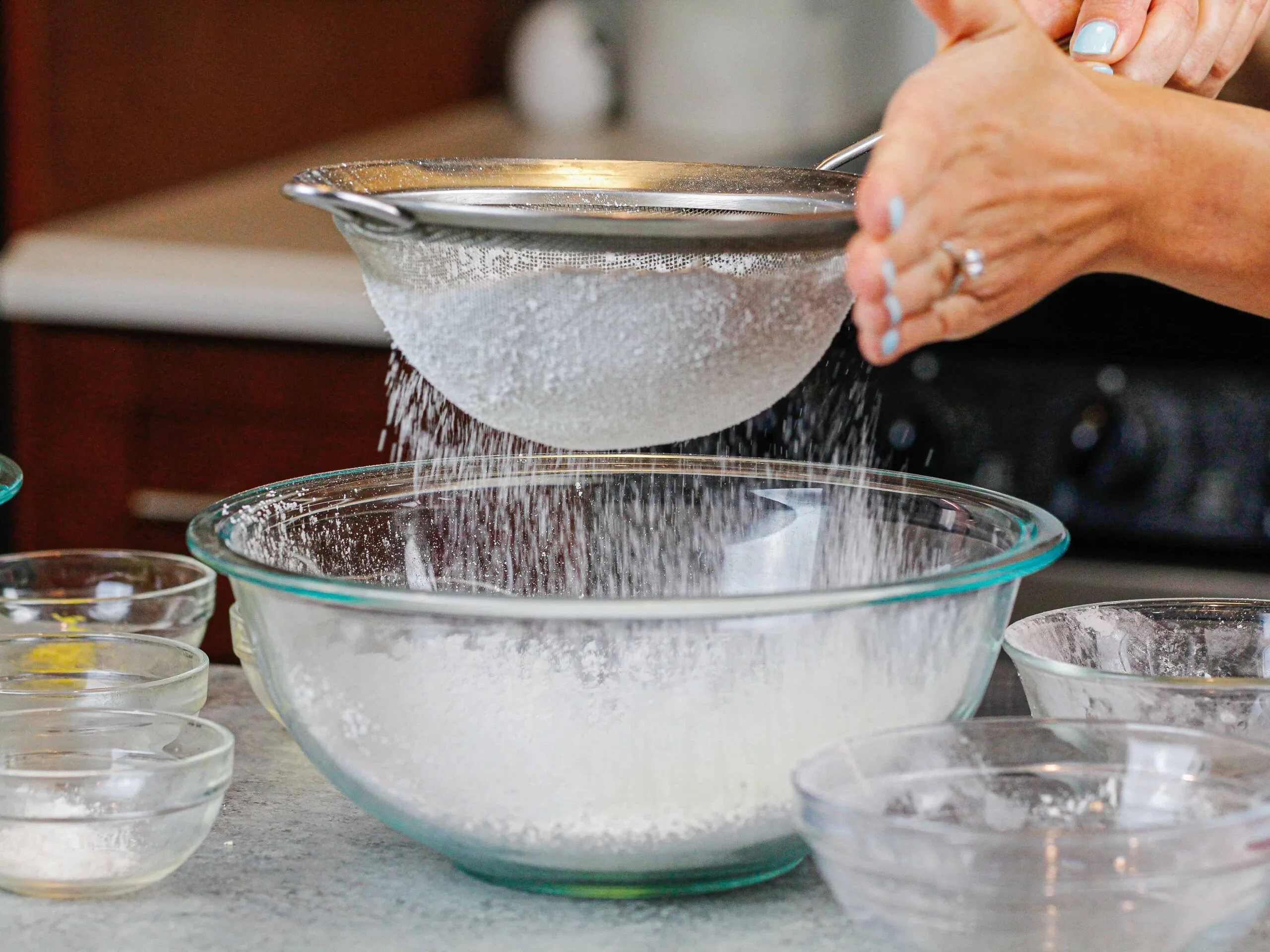 image of dry ingredients being sifted into bowl to make french macarons