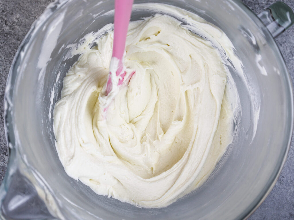 image of vanilla american buttercream in bowl that's been stirred with a spatula to make it super smooth