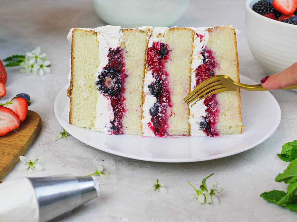 image of a slice of berry chantilly cake that's been placed on a plate and is ready to be enjoyed