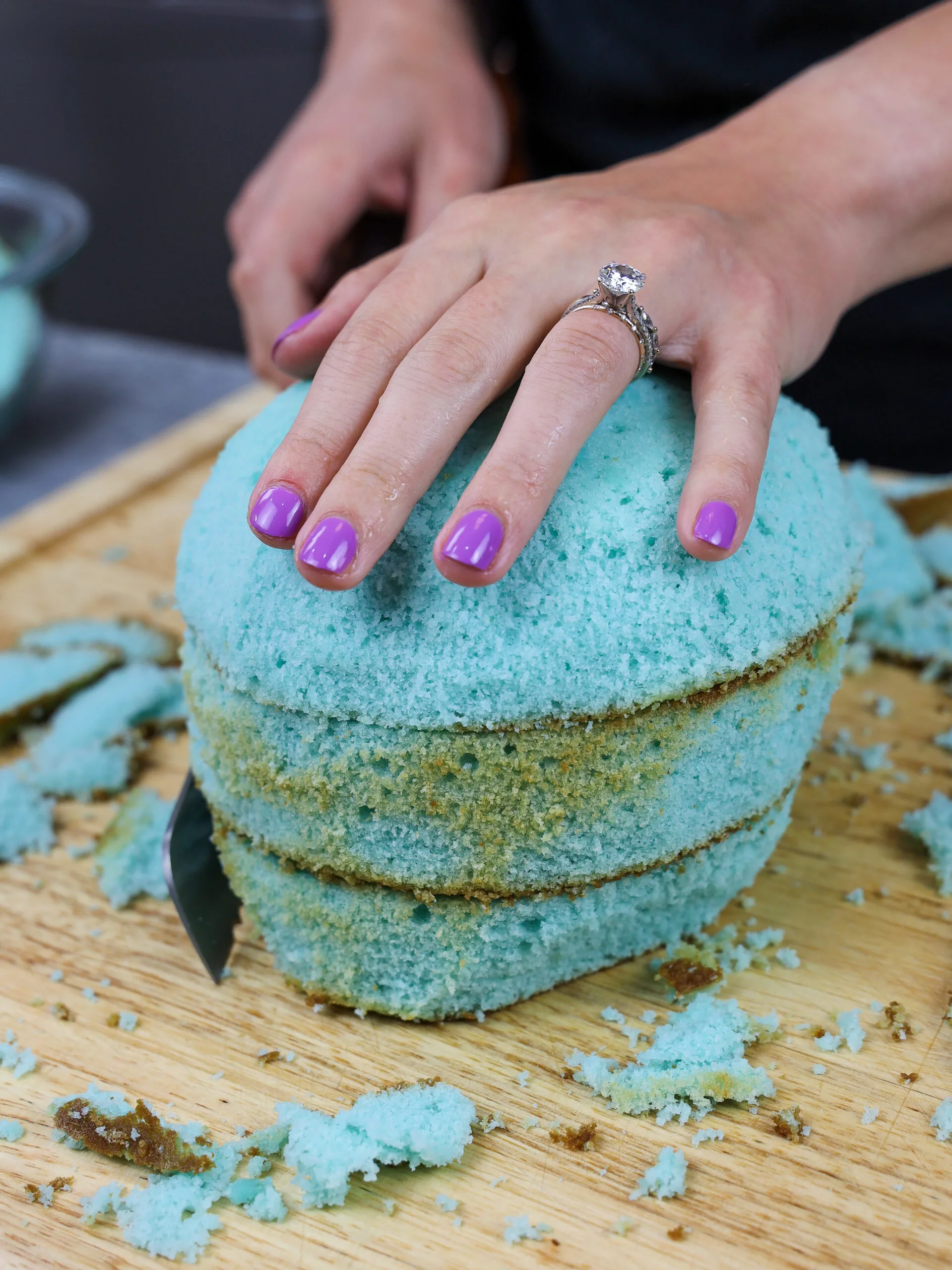 image of blue cake layers being trimmed to make a narwhal cake