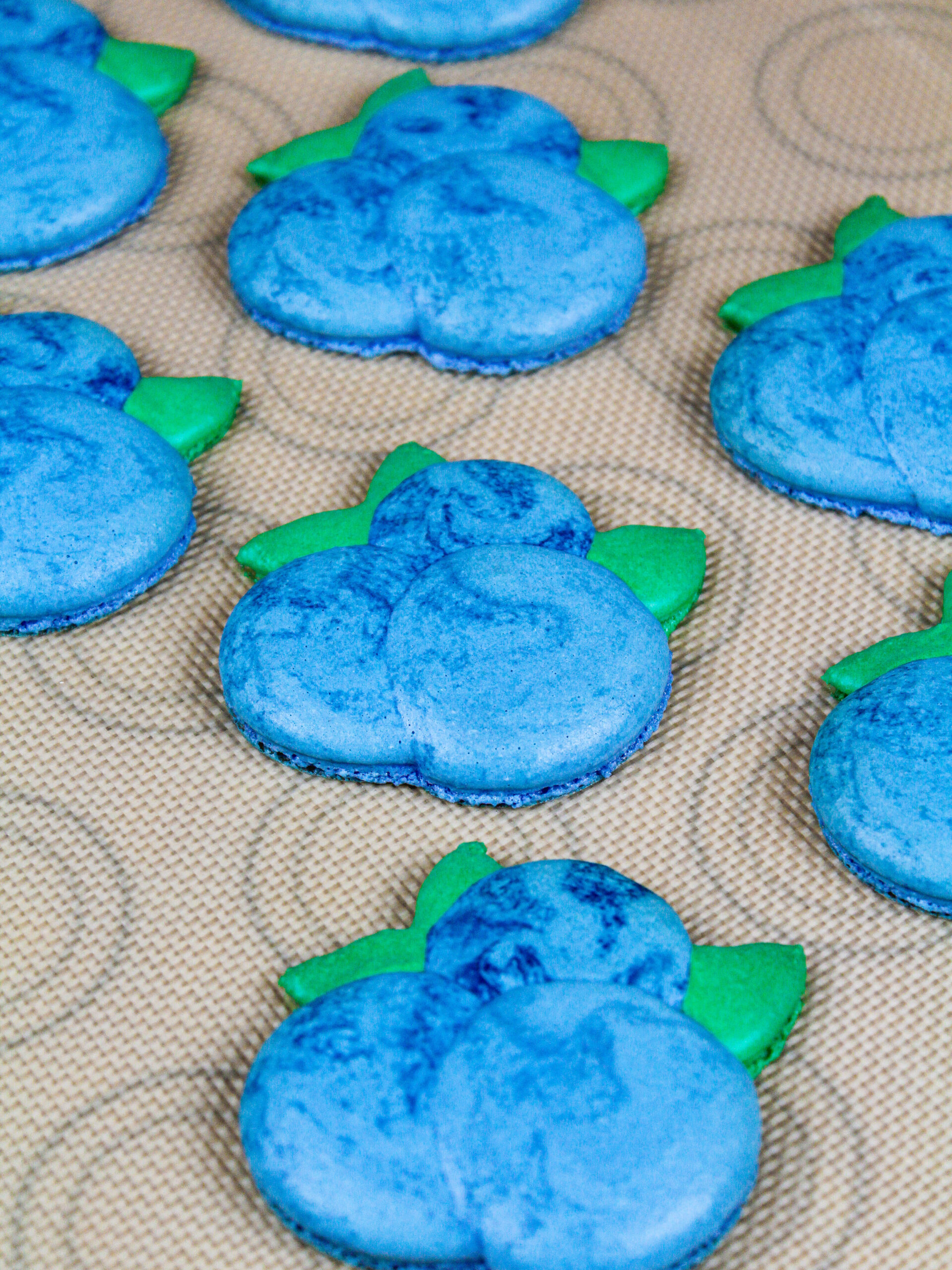 image of blueberry macaron shells that have been baked and have perfect little feet
