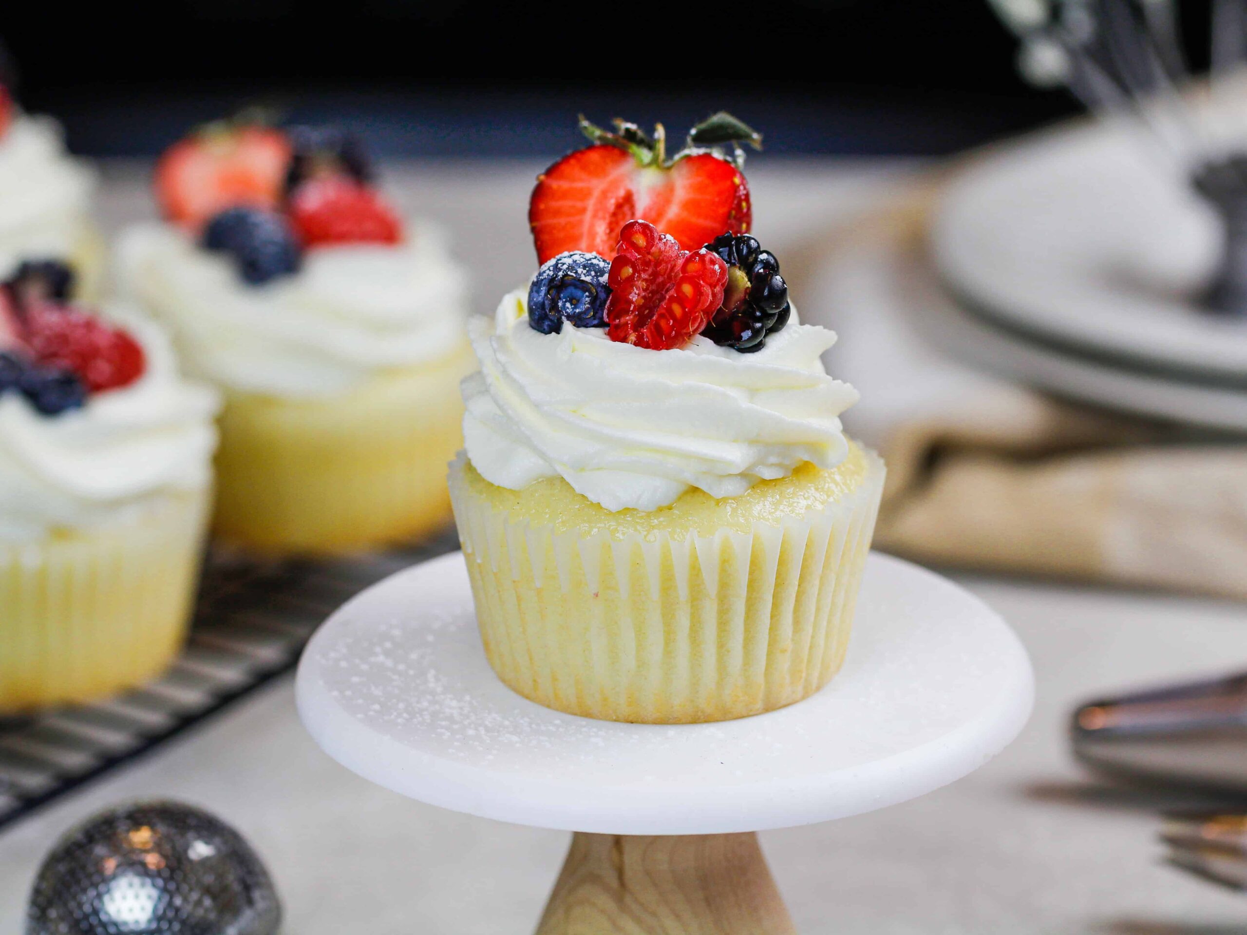 image of cupcakes topped with whipped cream frosting and fresh fruit