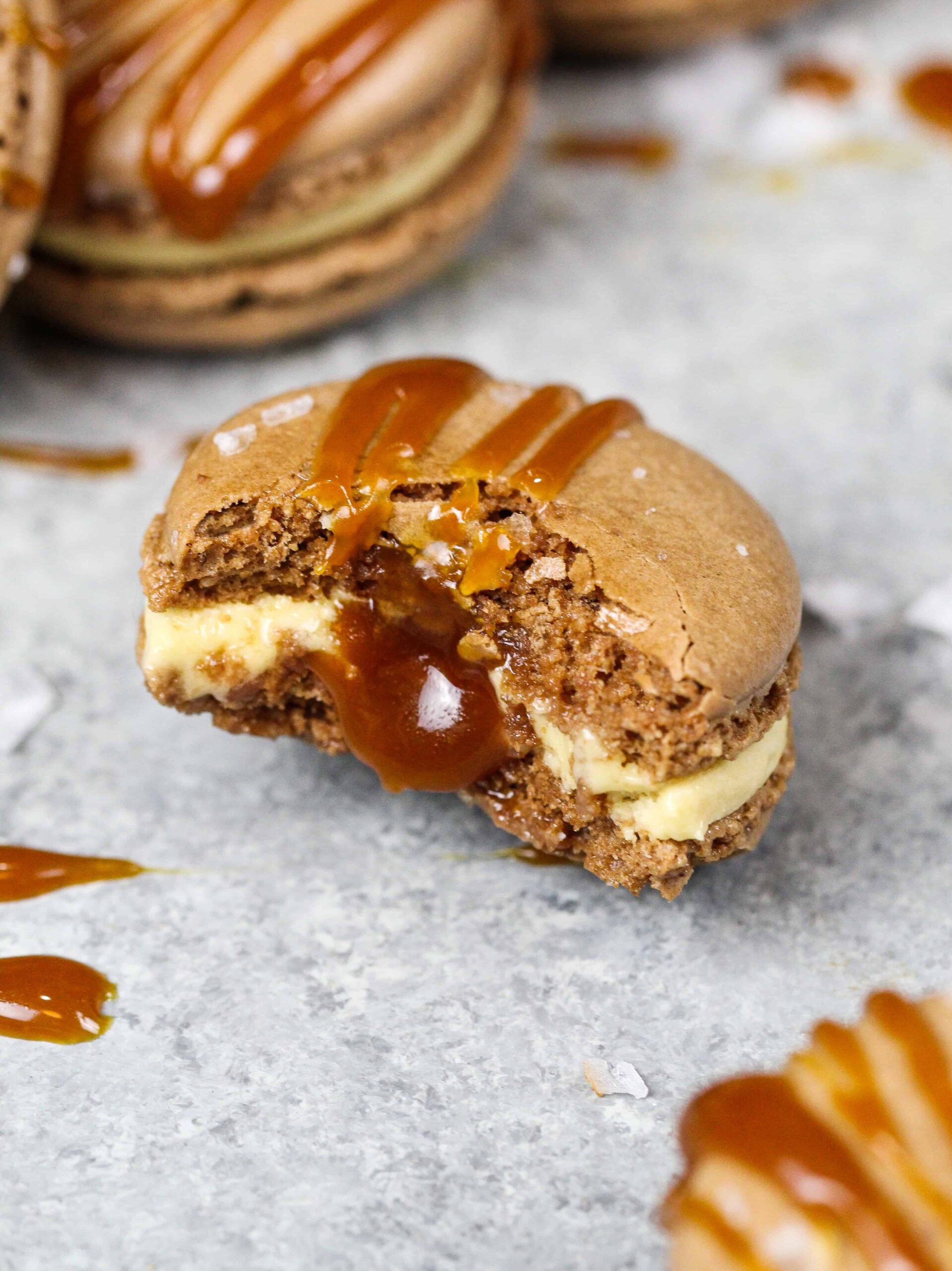 image of a salted caramel macaron that's been bitten into to show how full the macaron shell is