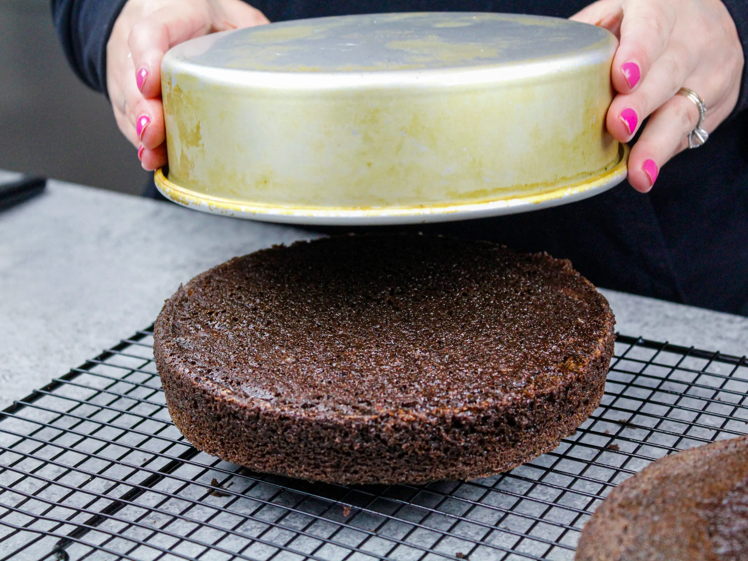 image of a cake layer popping out of a pan effortlessly thanks to homemade cake release