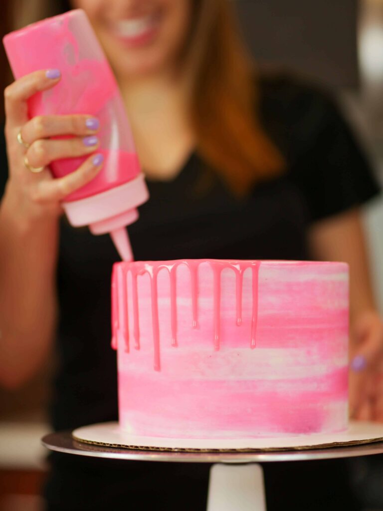 Adding pink drips to a vanilla layer cake