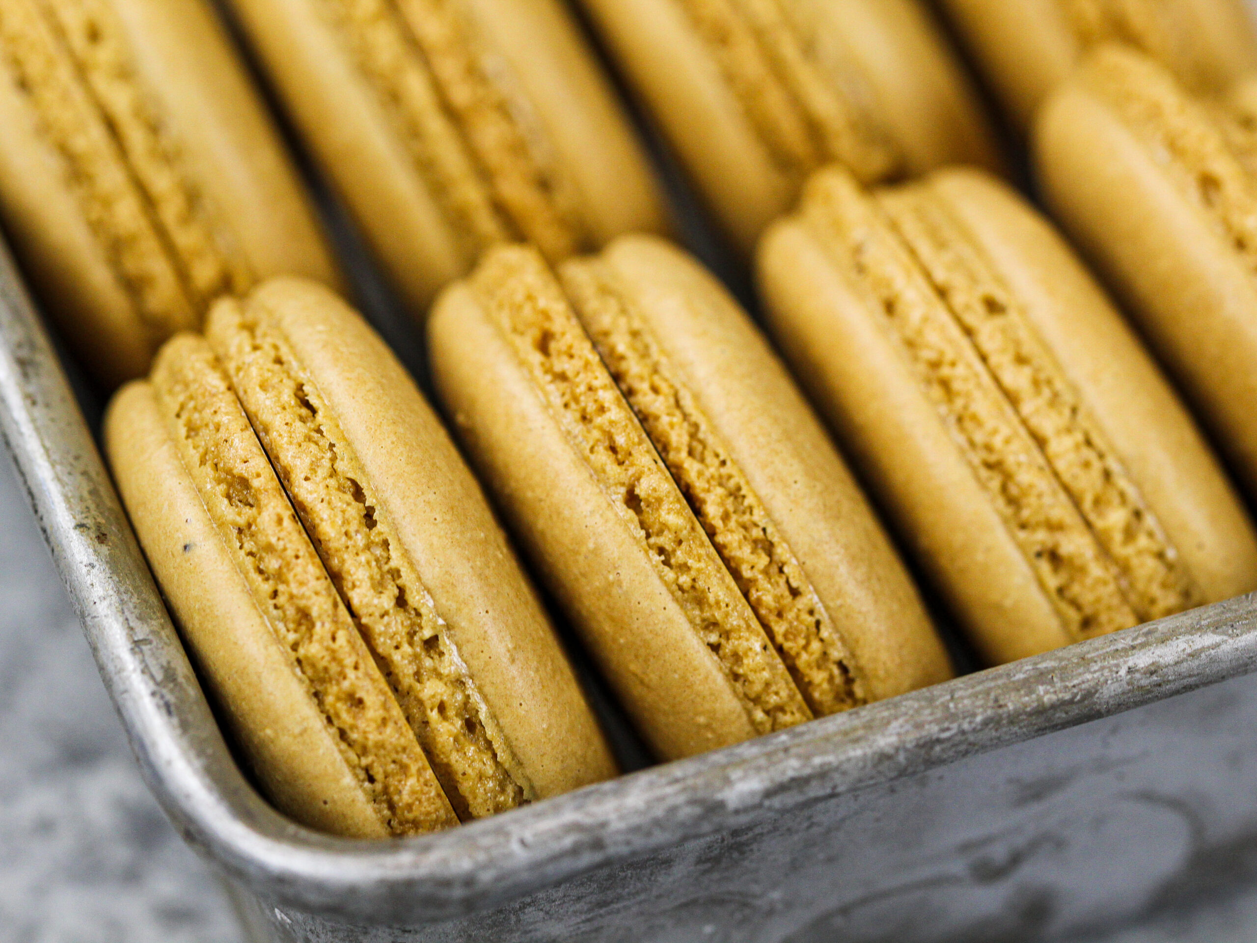 image of coffee macaron shells with perfect feed that have baked and cooled that are ready to be filled