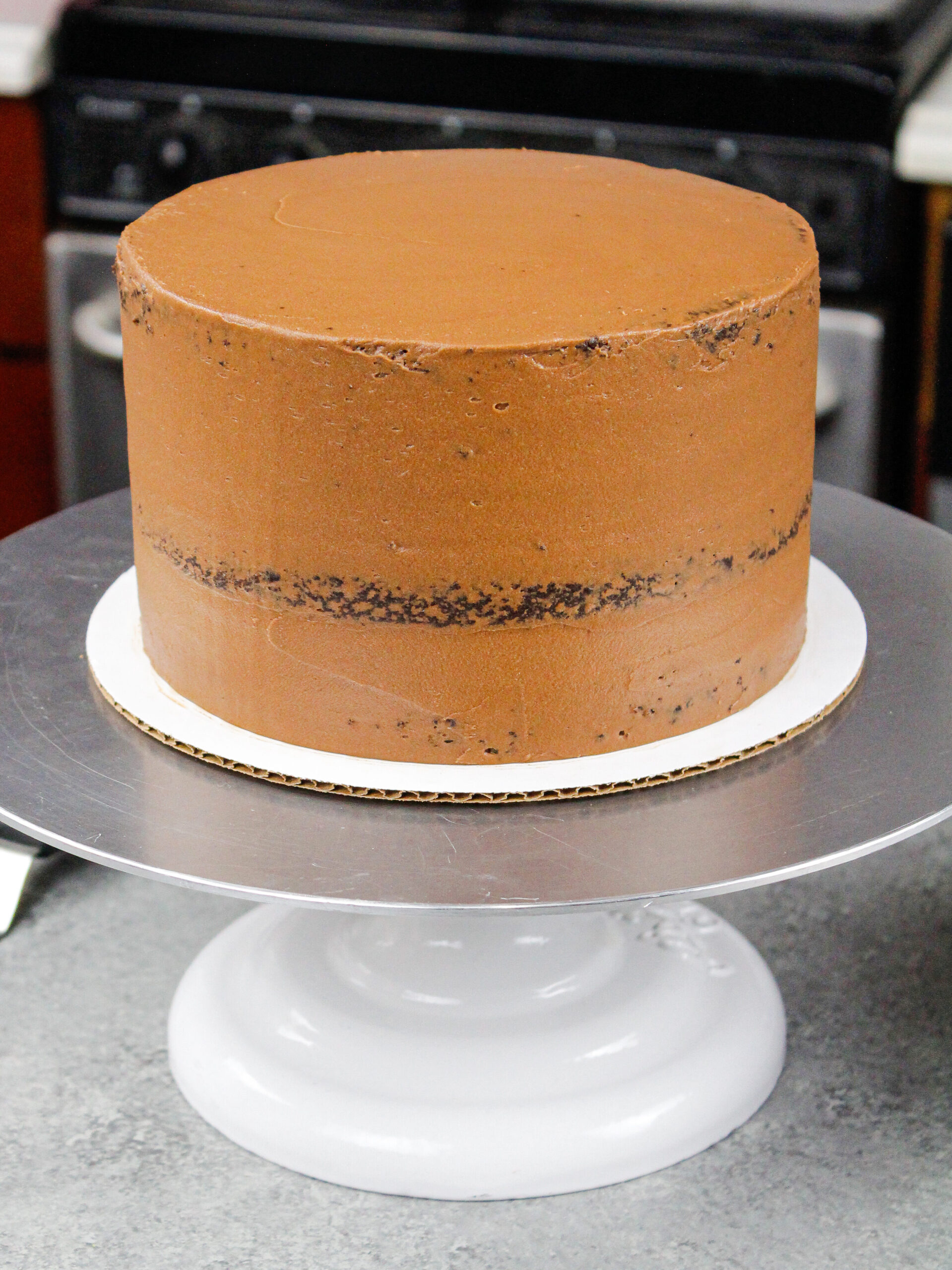 image of a chocolate cake that's been crumb coated and chilled and is ready for its second layer of chocolate buttercream frosting