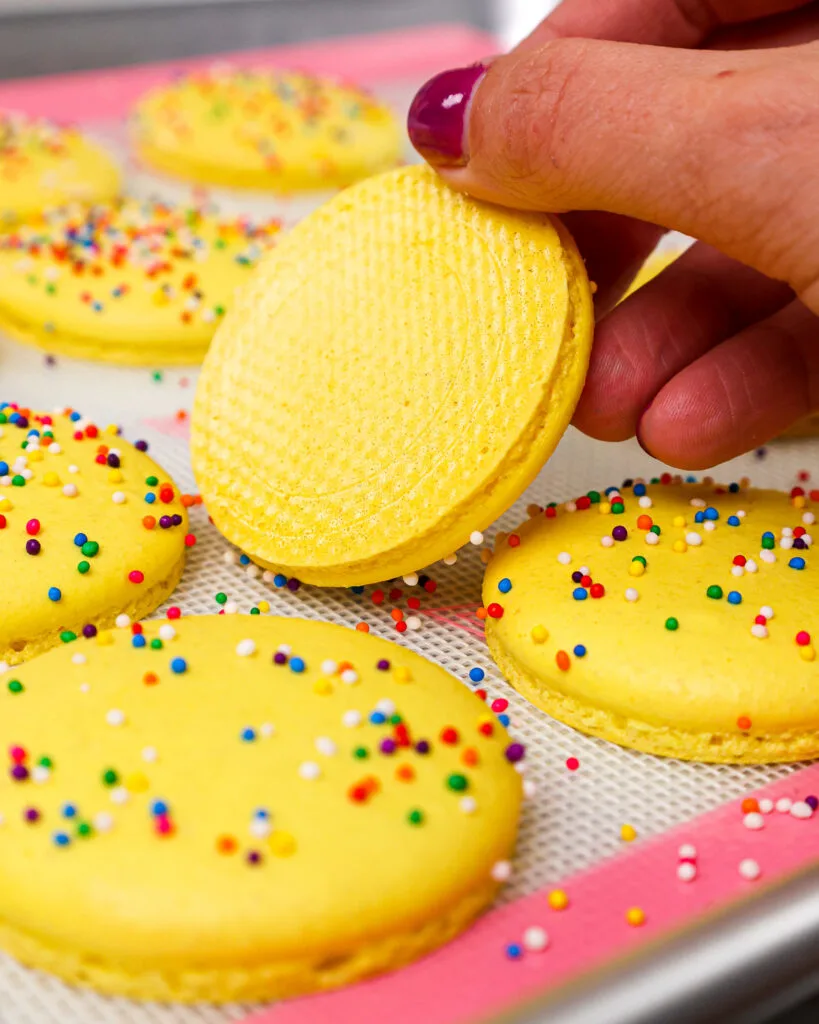image of funfetti sprinkle macaron shells that have been properly baked and  easily peel off the mat