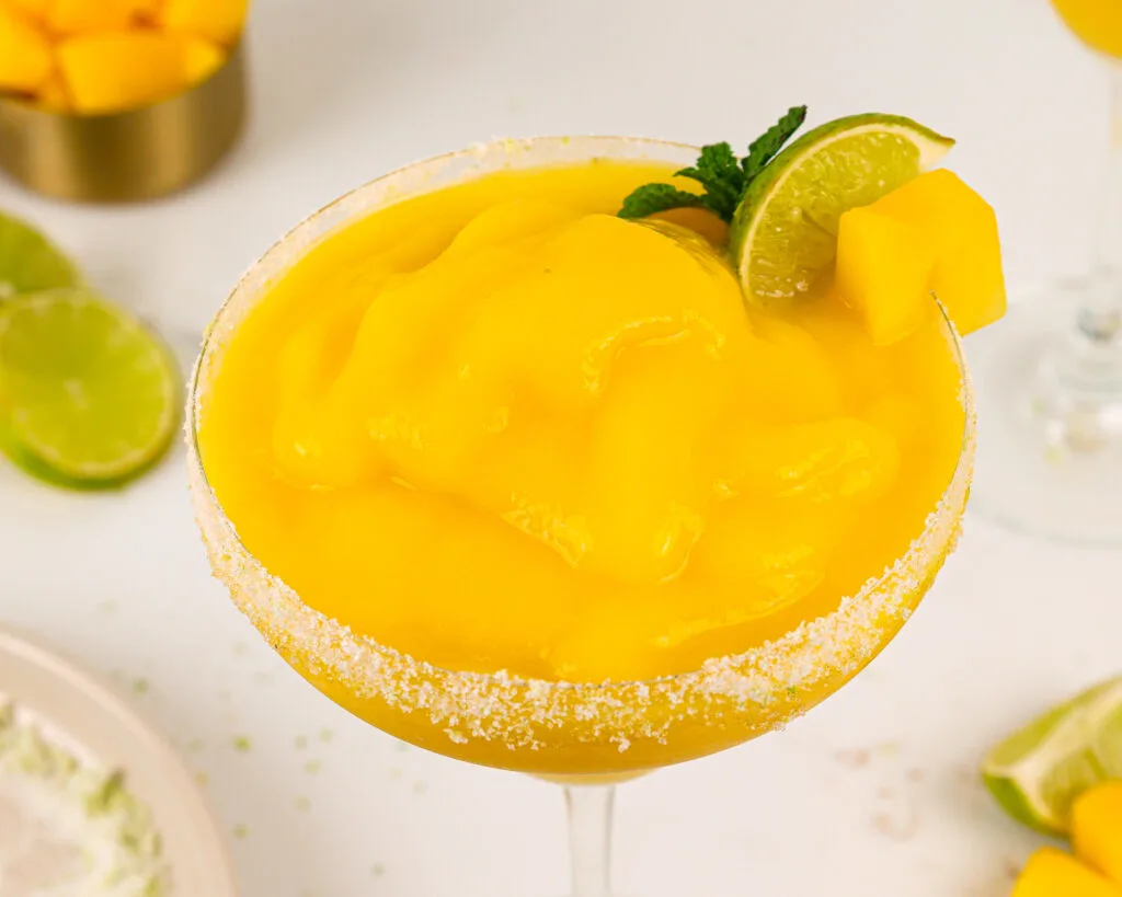 image of a frozen mango margarita made with a sugar lime rim
