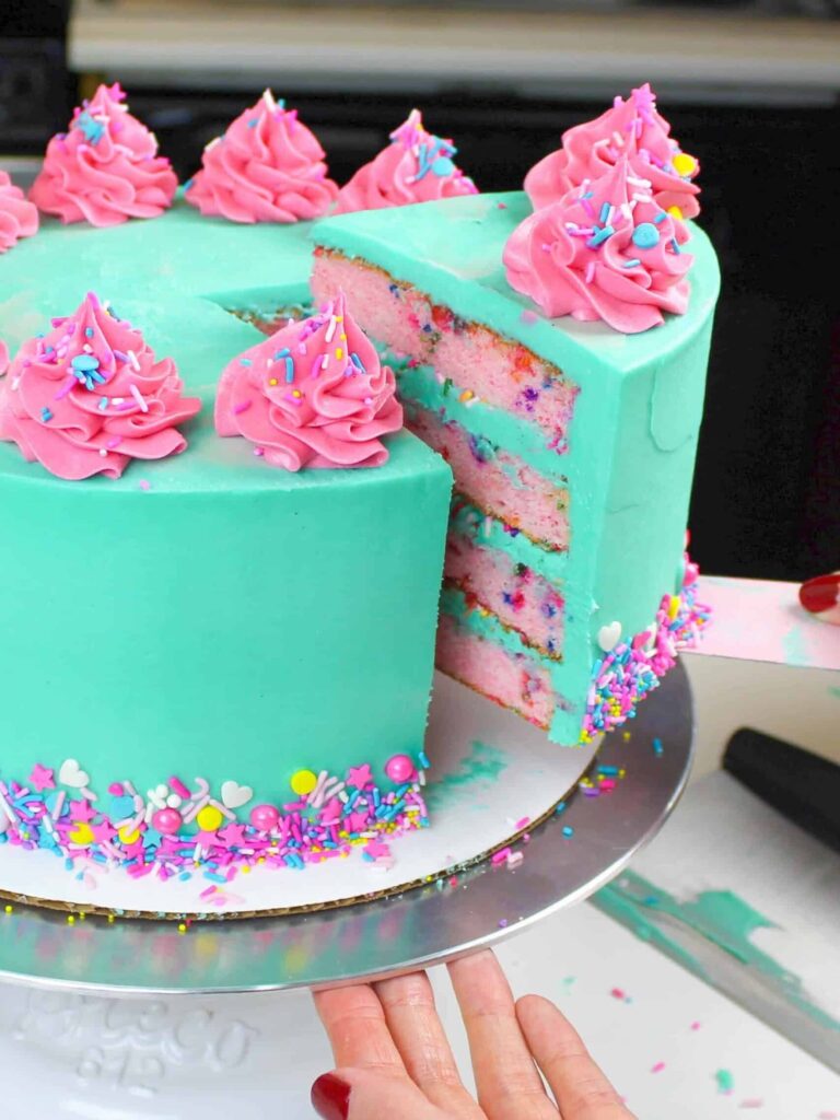 image of a cute funfetti cake with pink cake layers and turquoise frosting