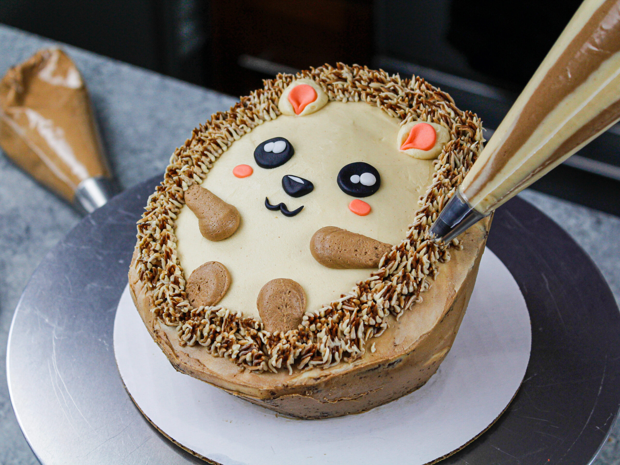 image of a buttercream hedgehog cake being piped with buttercream to look like quills