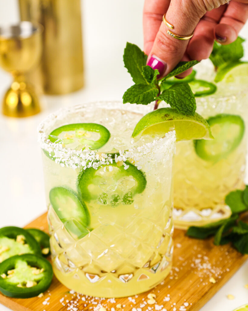 image of a spicy skinny margarita recipe being garnished with a sprig of mint
