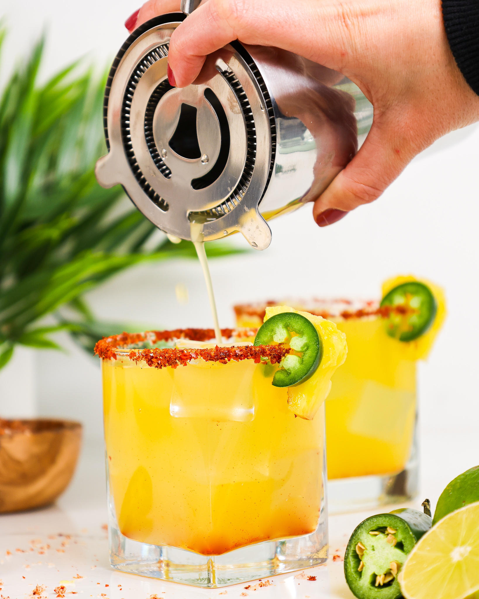 image of spicy pineapple margarita being poured into a glass