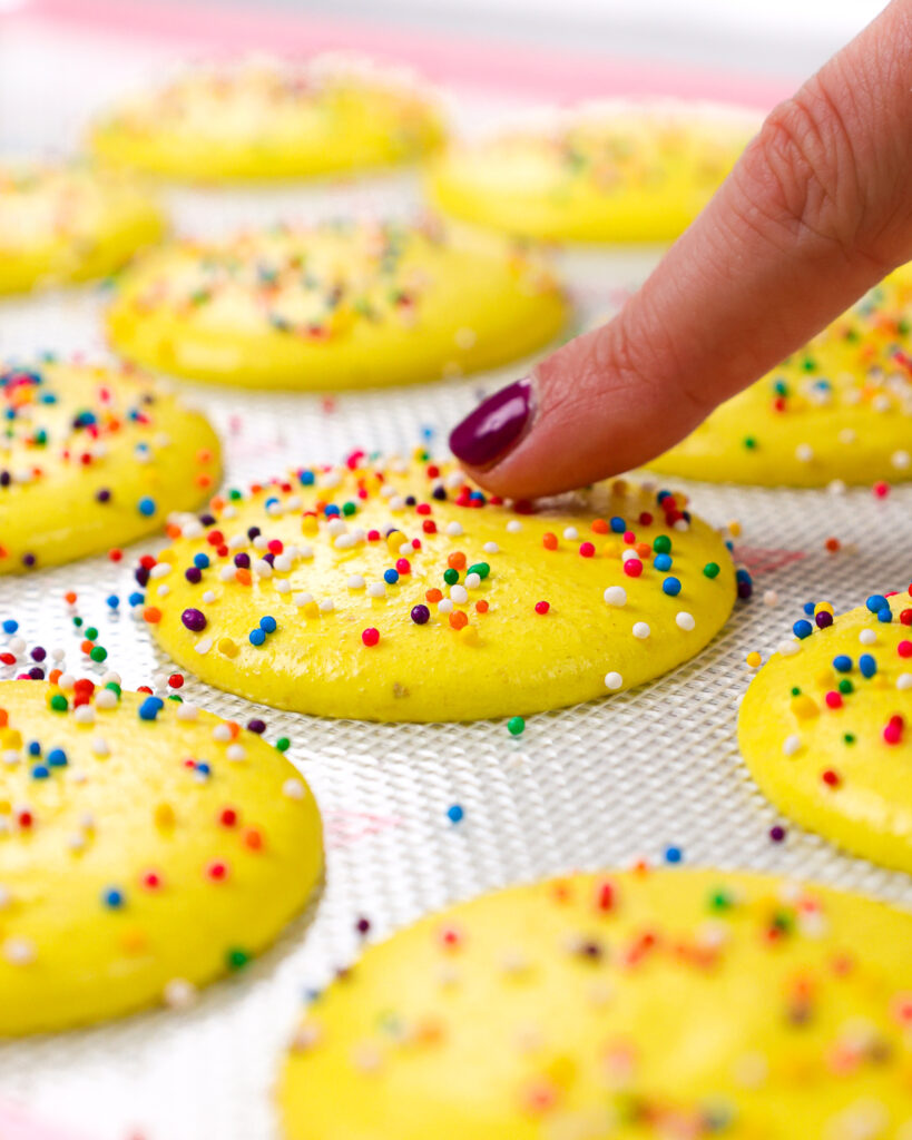 image of sprinkle macaron shells that have been rested and have formed a skin and are ready to be baked