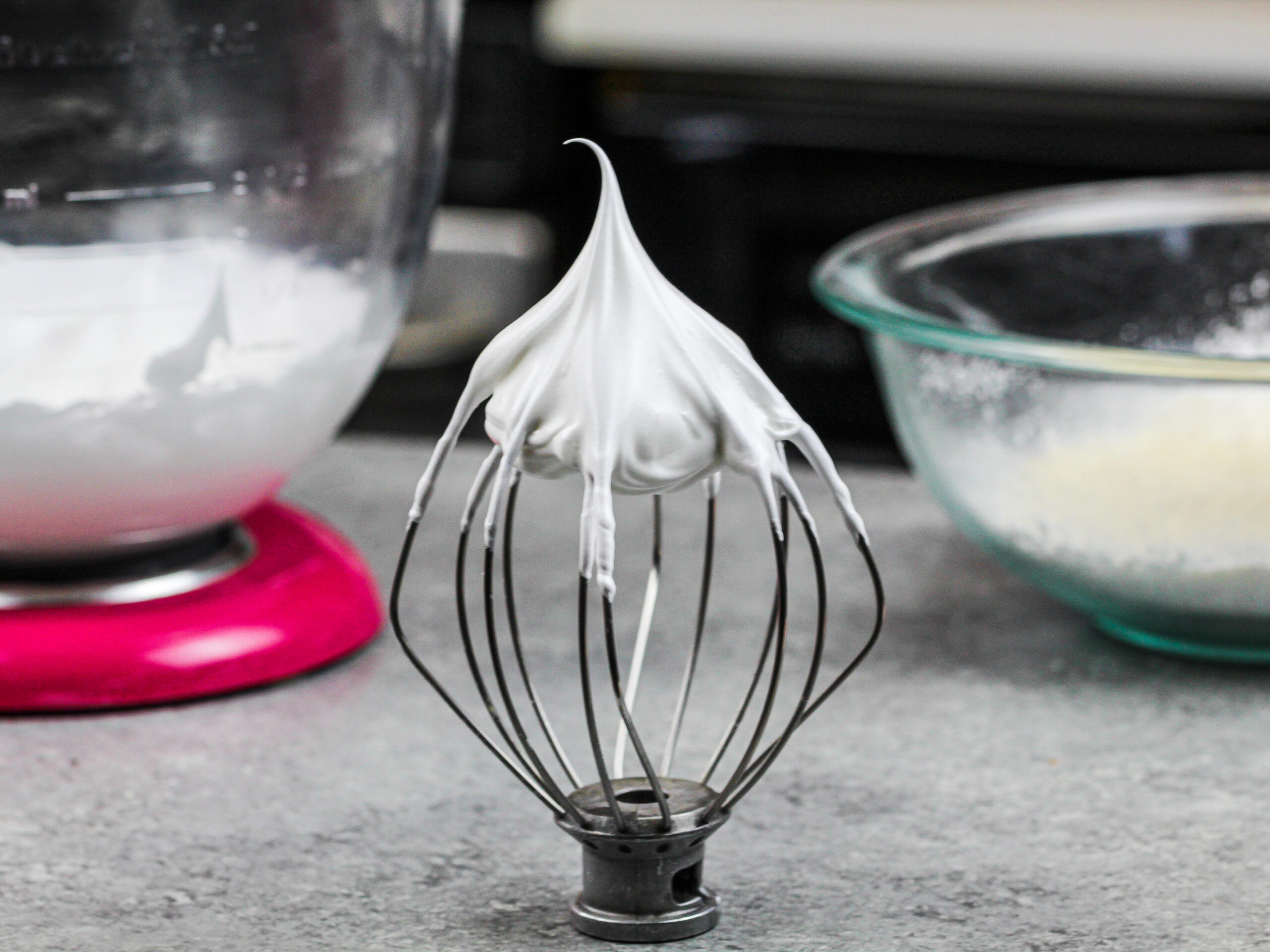 image of french meringue on a whisk of a kitchenaid mixer that has stiff peaks