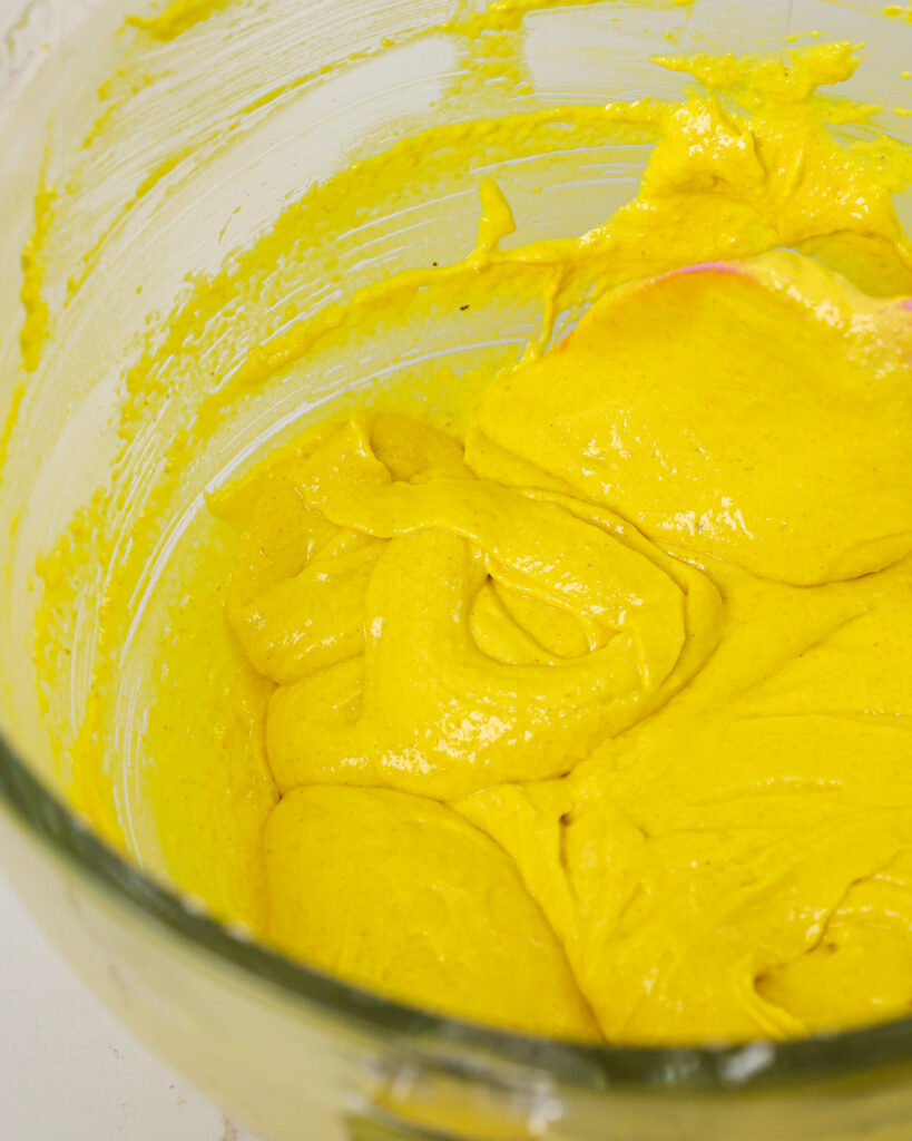 image of yellow macaron batter that's been mixed to the perfect consistency and passed the figure 8 test