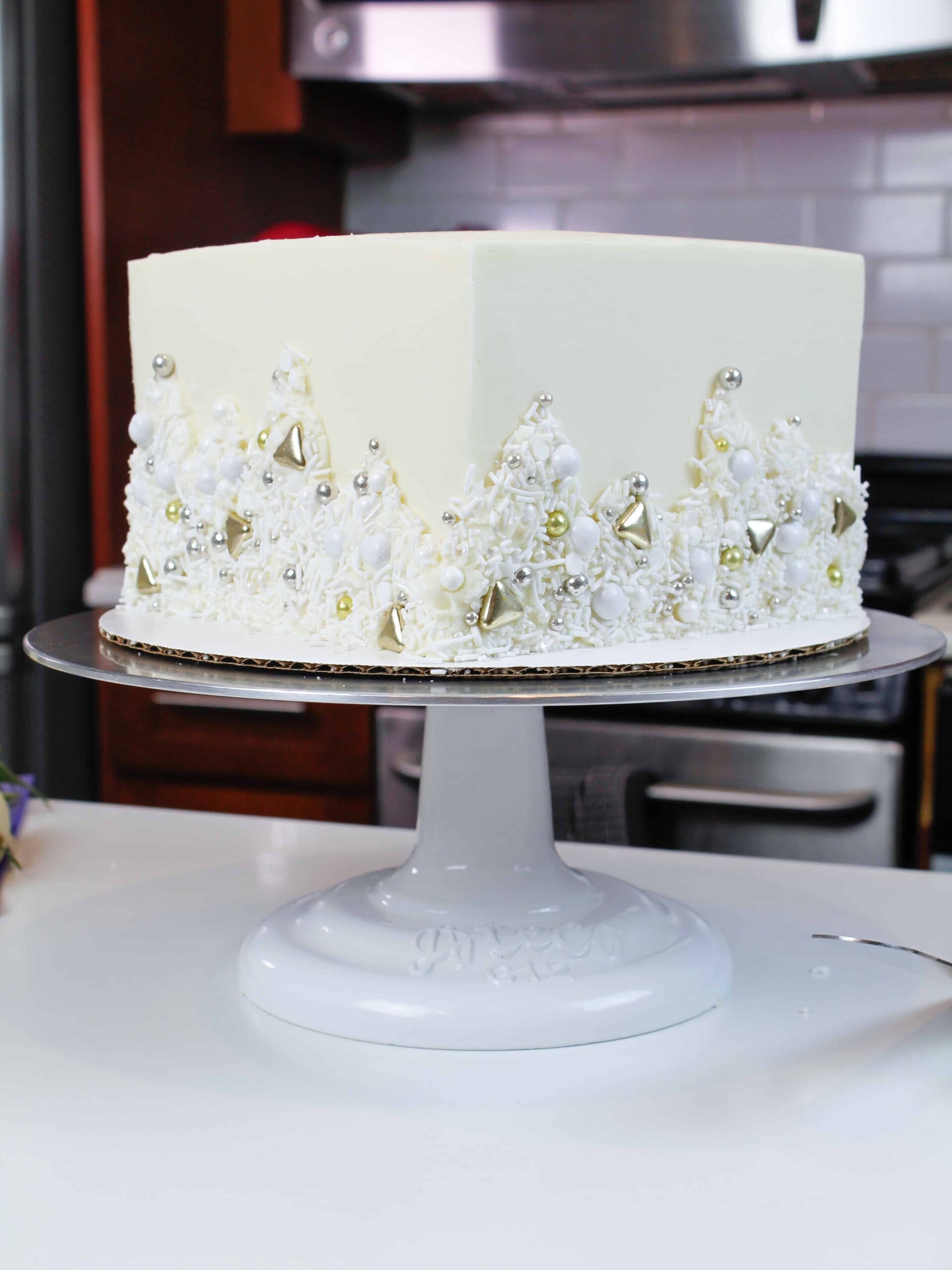 photo of square white cake decorated with a metallic sprinkle blend