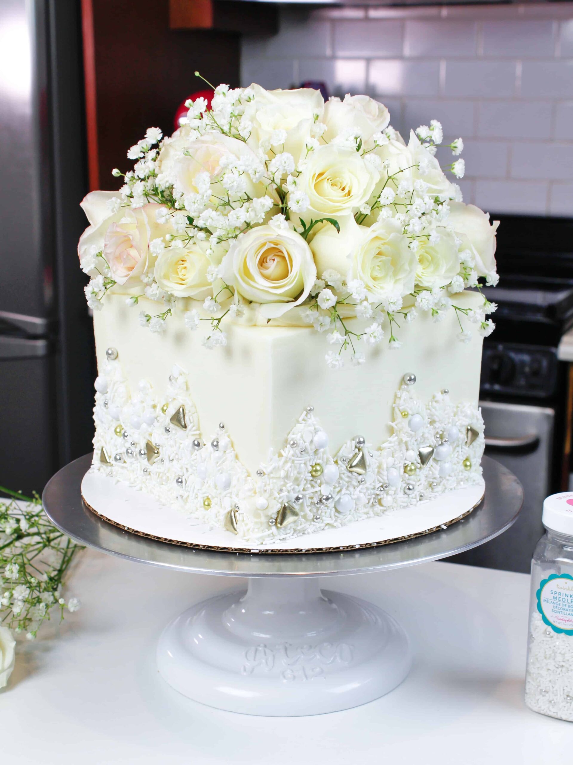 photo of white bridal shower cake, decorated with fresh flowers