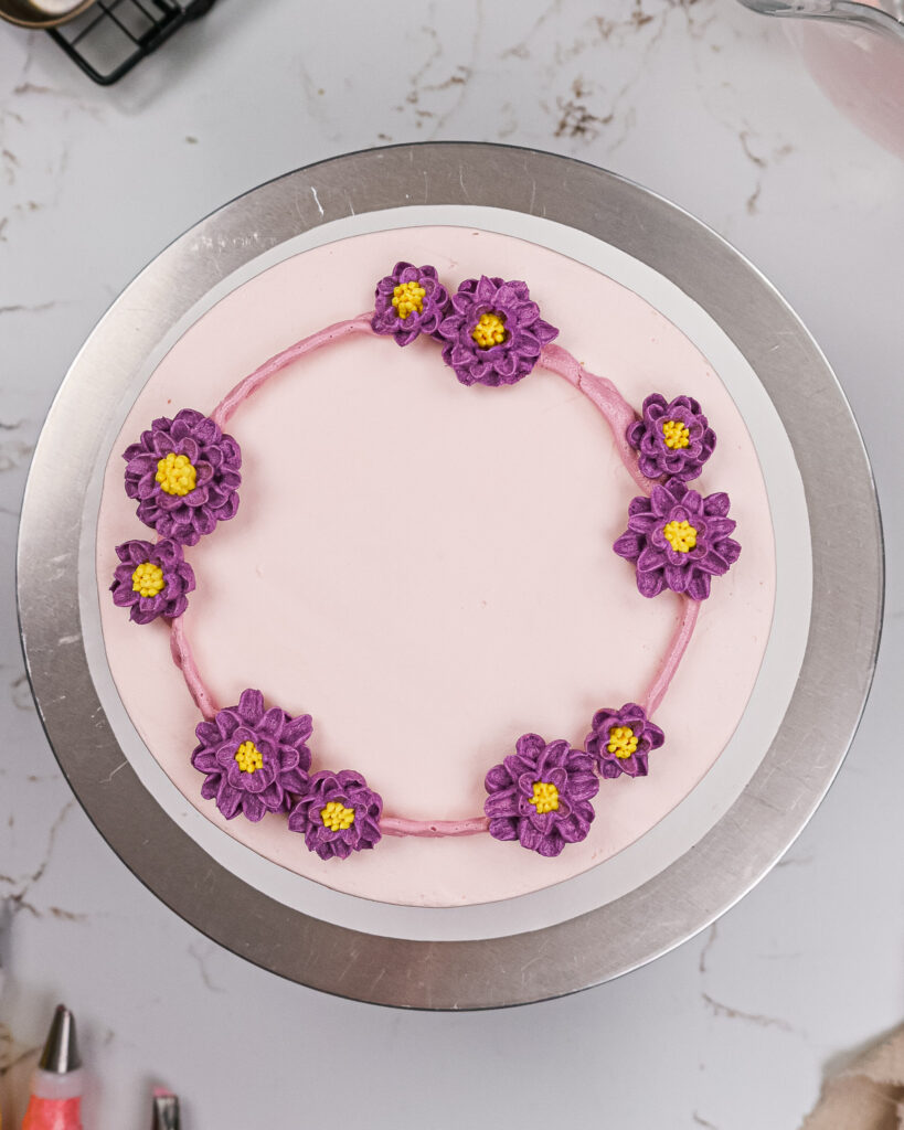 image of frozen buttercream flowers being placed on a cake