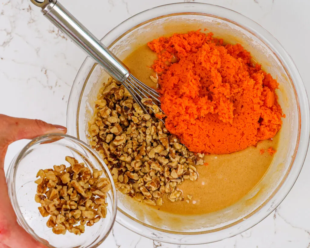 image of carrot cake cupcake batter being made with finely shredded carrots and chopped walnuts