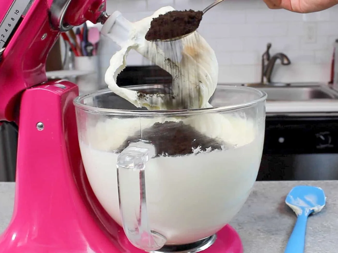 image of crushed Oreos being added into buttercream to make oreo frosting