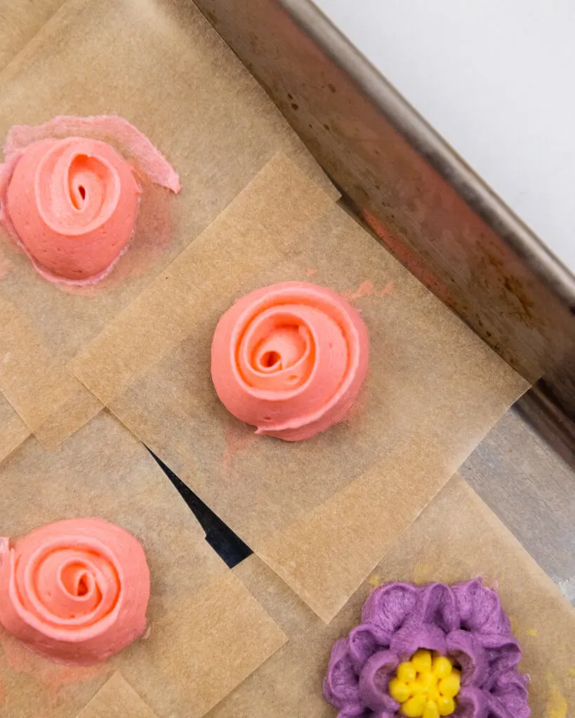 image of a ribbon rose that's been piped in salmon colored buttercream frosting 