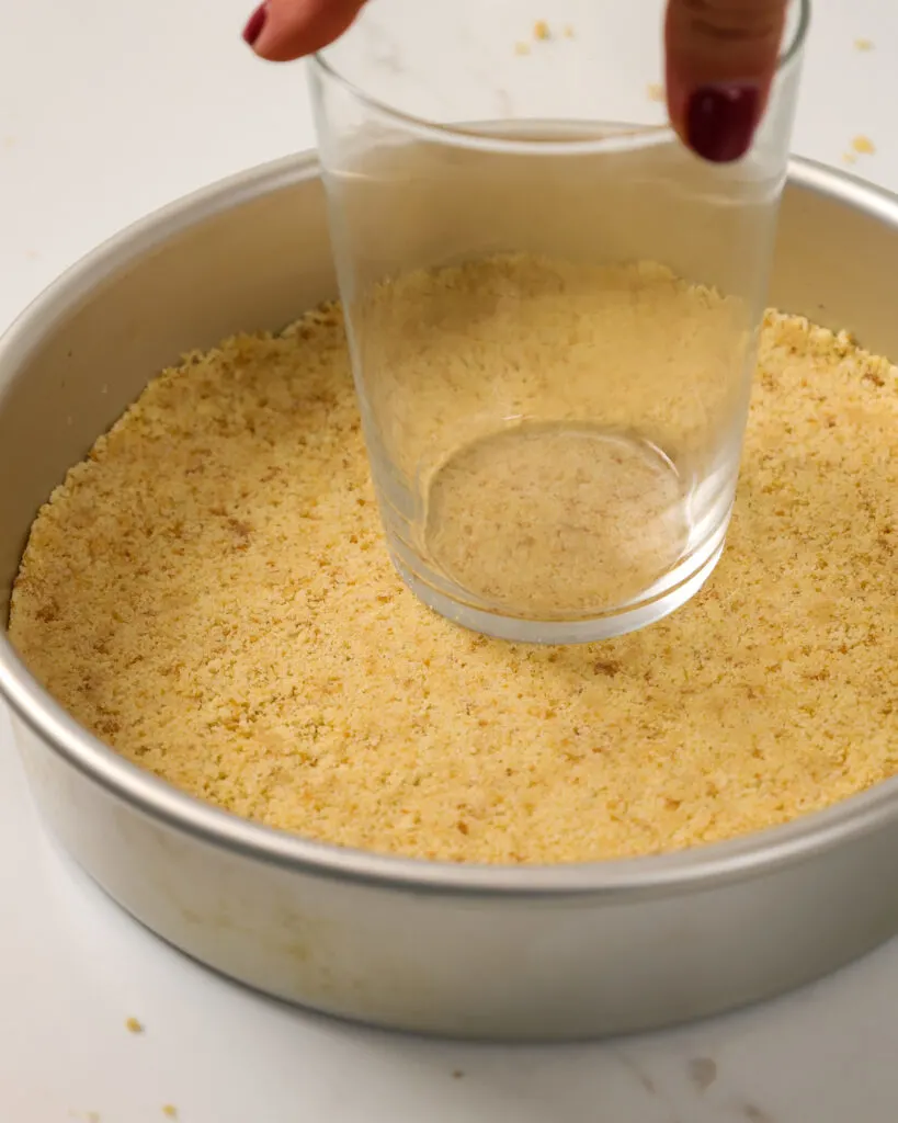 image of a shortbread crust being compressed to make shortbread crusted cake layers