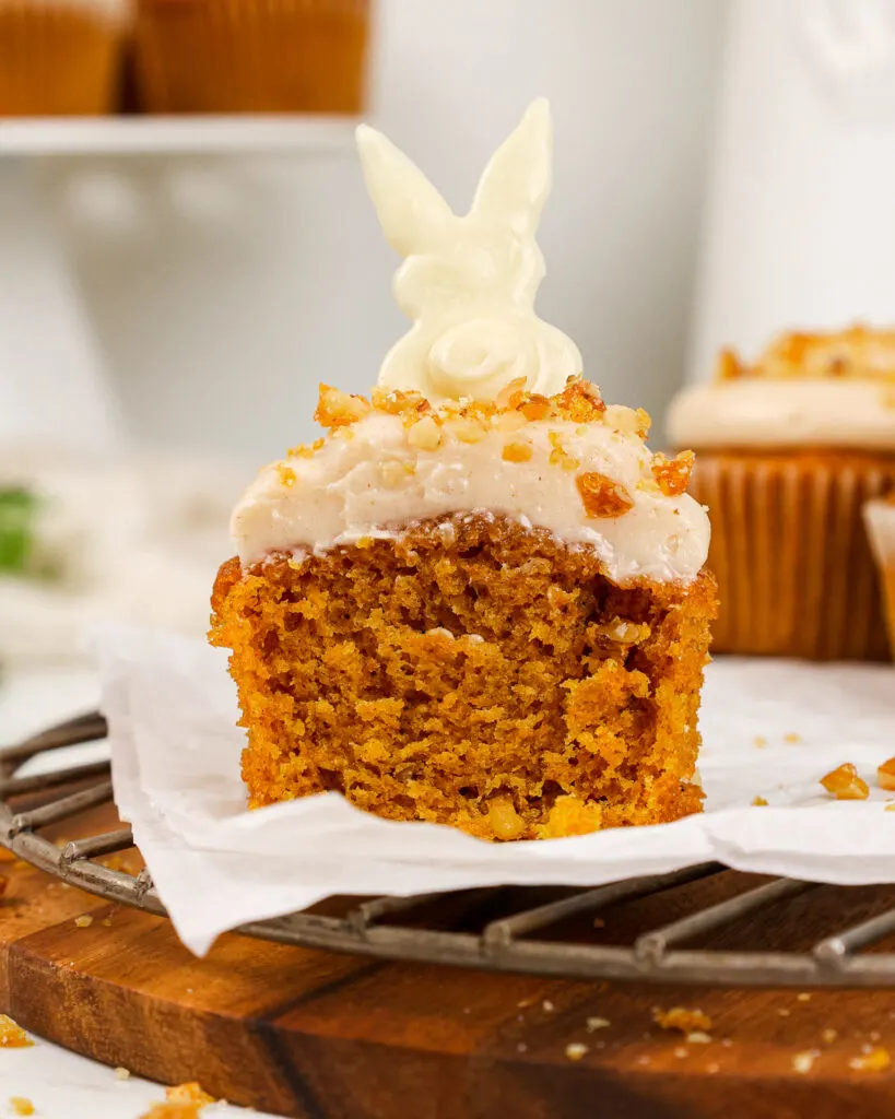 image of a moist easter carrot cake cupcake that's been cut into to show how tender and soft it is