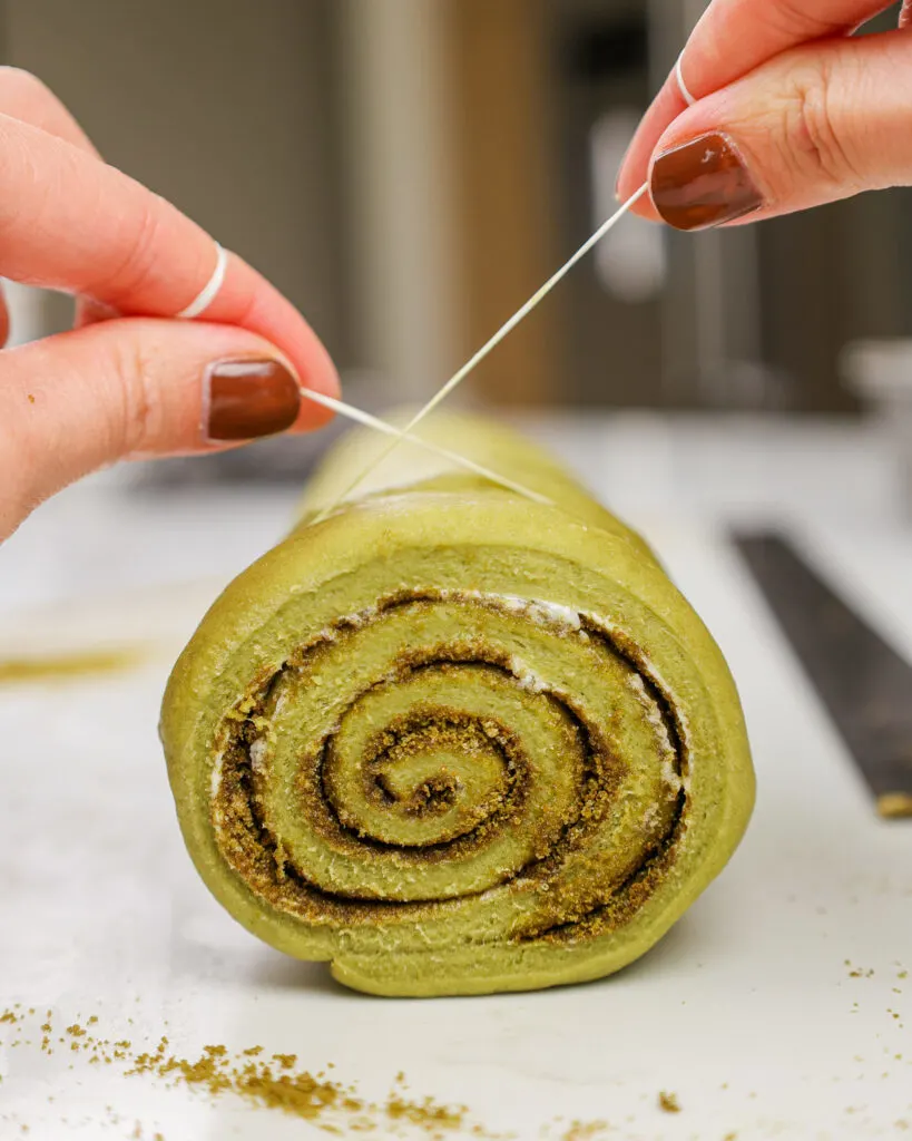 image of matcha cinnamon rolls being cut with dental floss to get super clean cuts