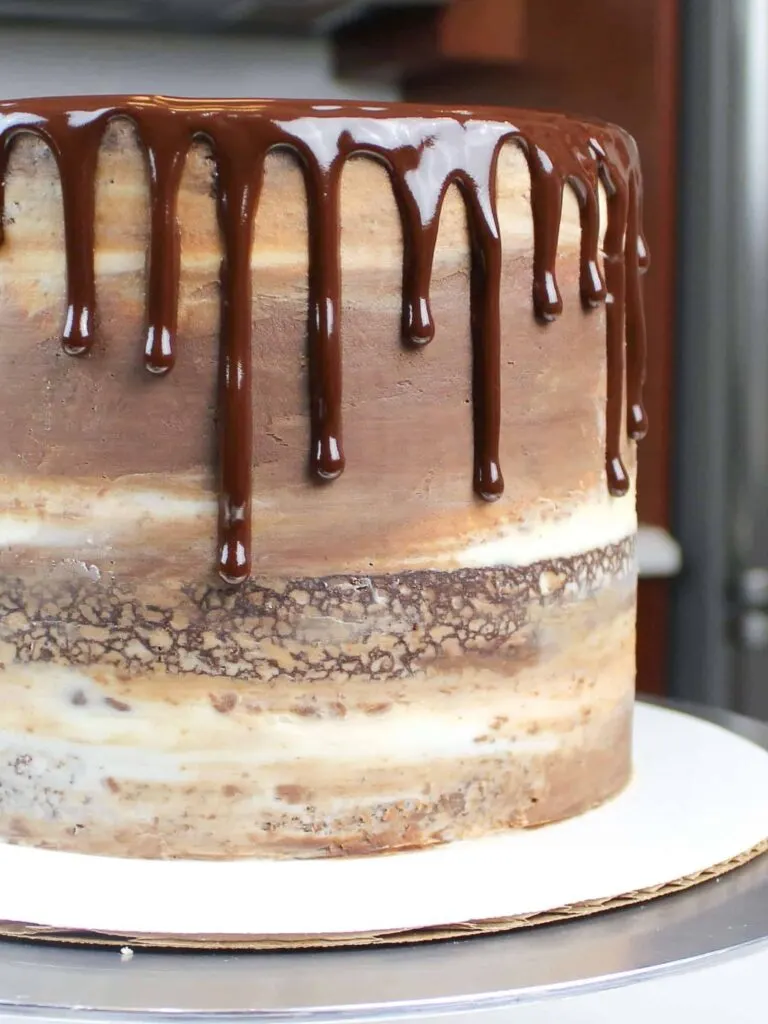 chocolate ganache drips on a semi naked frosted chocolate cake