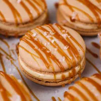 image of a salted caramel macaron decorated with a drizzle of caramel and a sprinkle of flakey sea salt