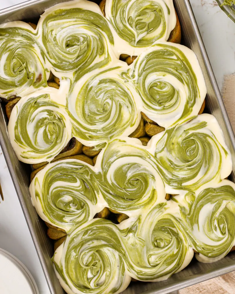 image of matcha cinnamon rolls that have been frosted with cream cheese matcha frosting and are ready to be eaten