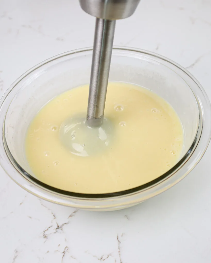 image of white chocolate ganache being mixed with in immersion blender to make it silky smooth