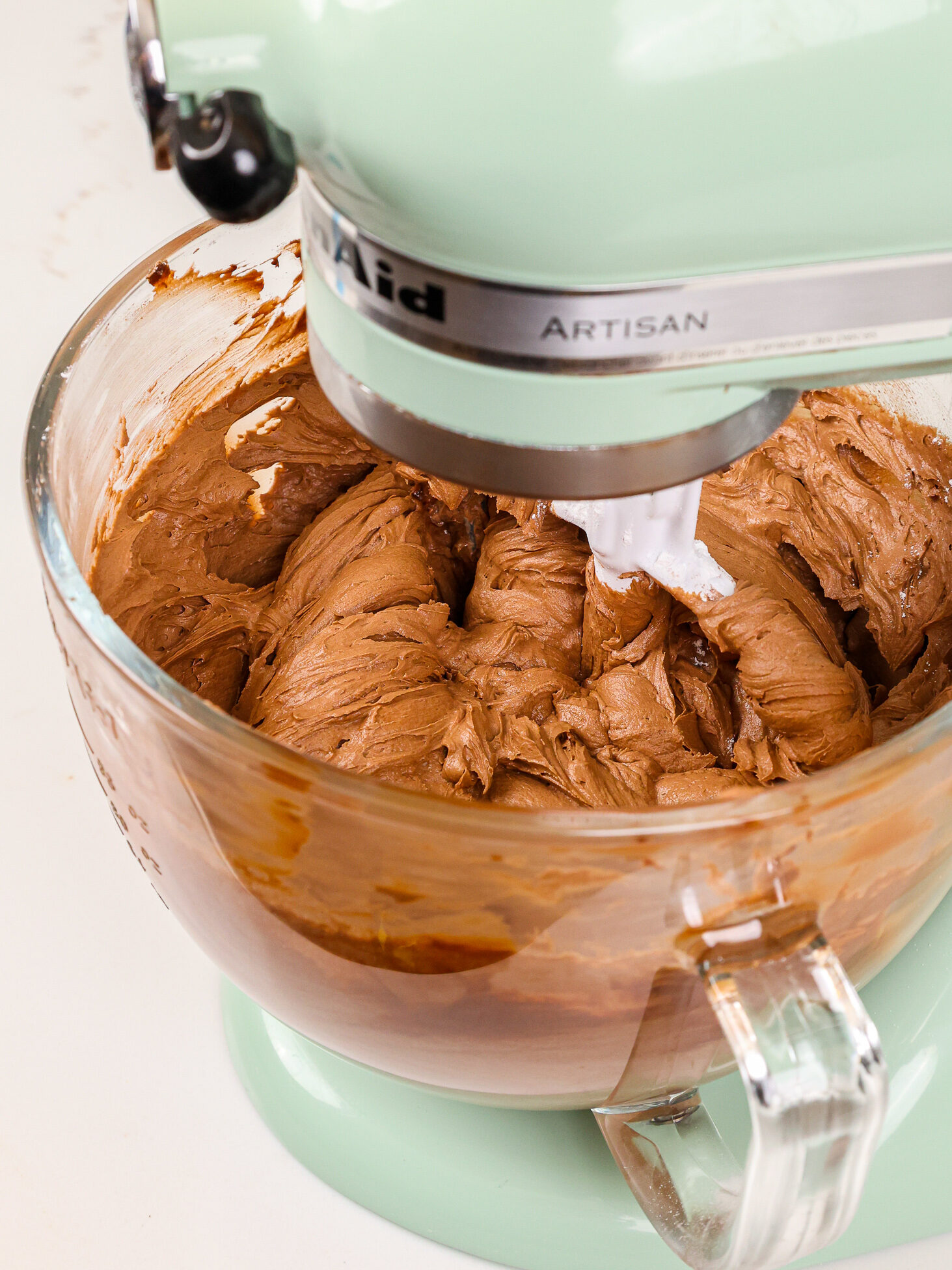 image of chocolate buttercream that's been mixed in a mint colored kitchenaid