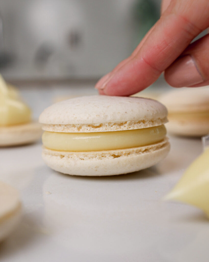 image of white chocolate ganache that's been used to fill a white macaron shell