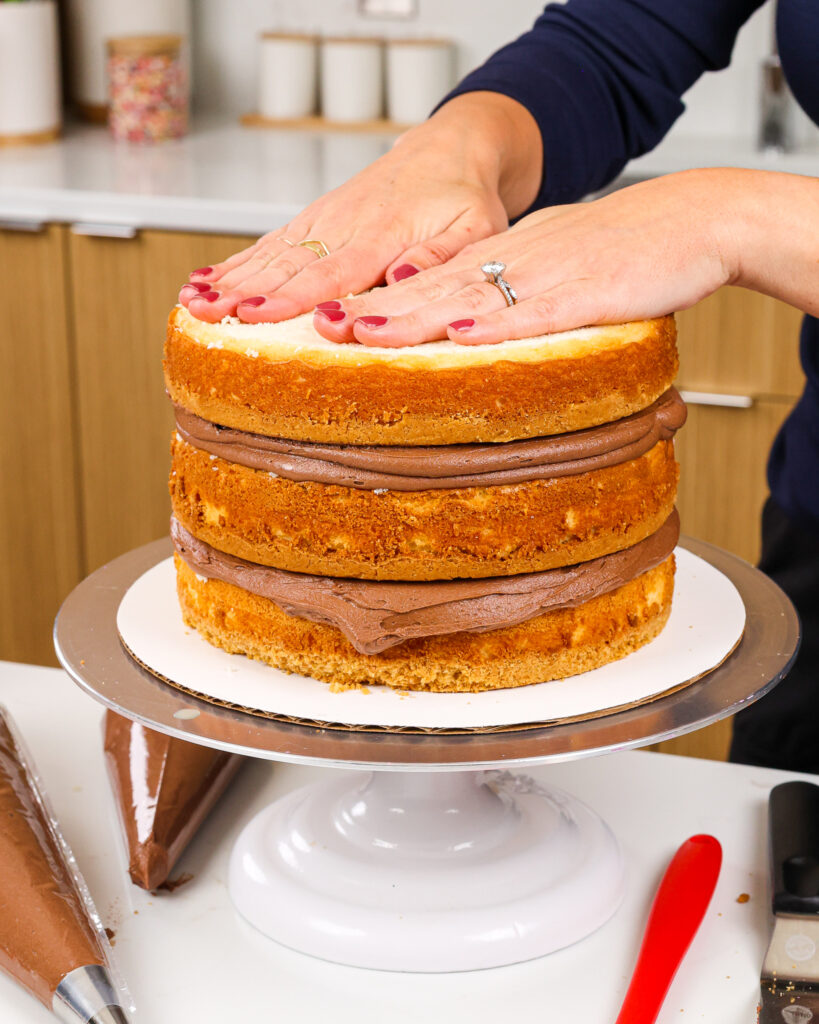 image of cake layers being filled and stacked to make a Twix cake