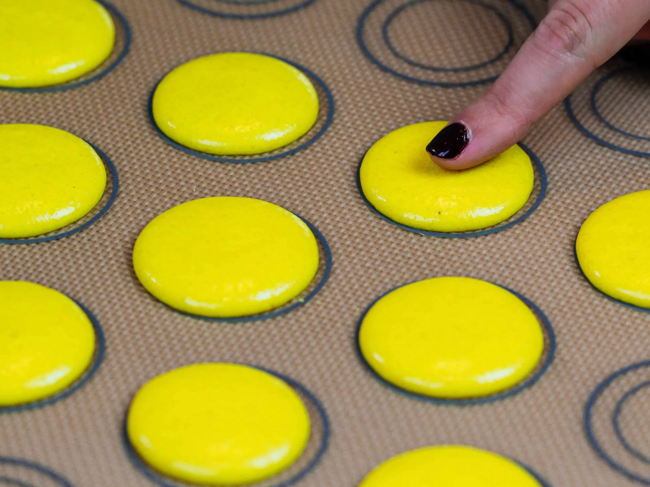 image of yellow macaron shells that have rested and have formed a touchable skin before being baked