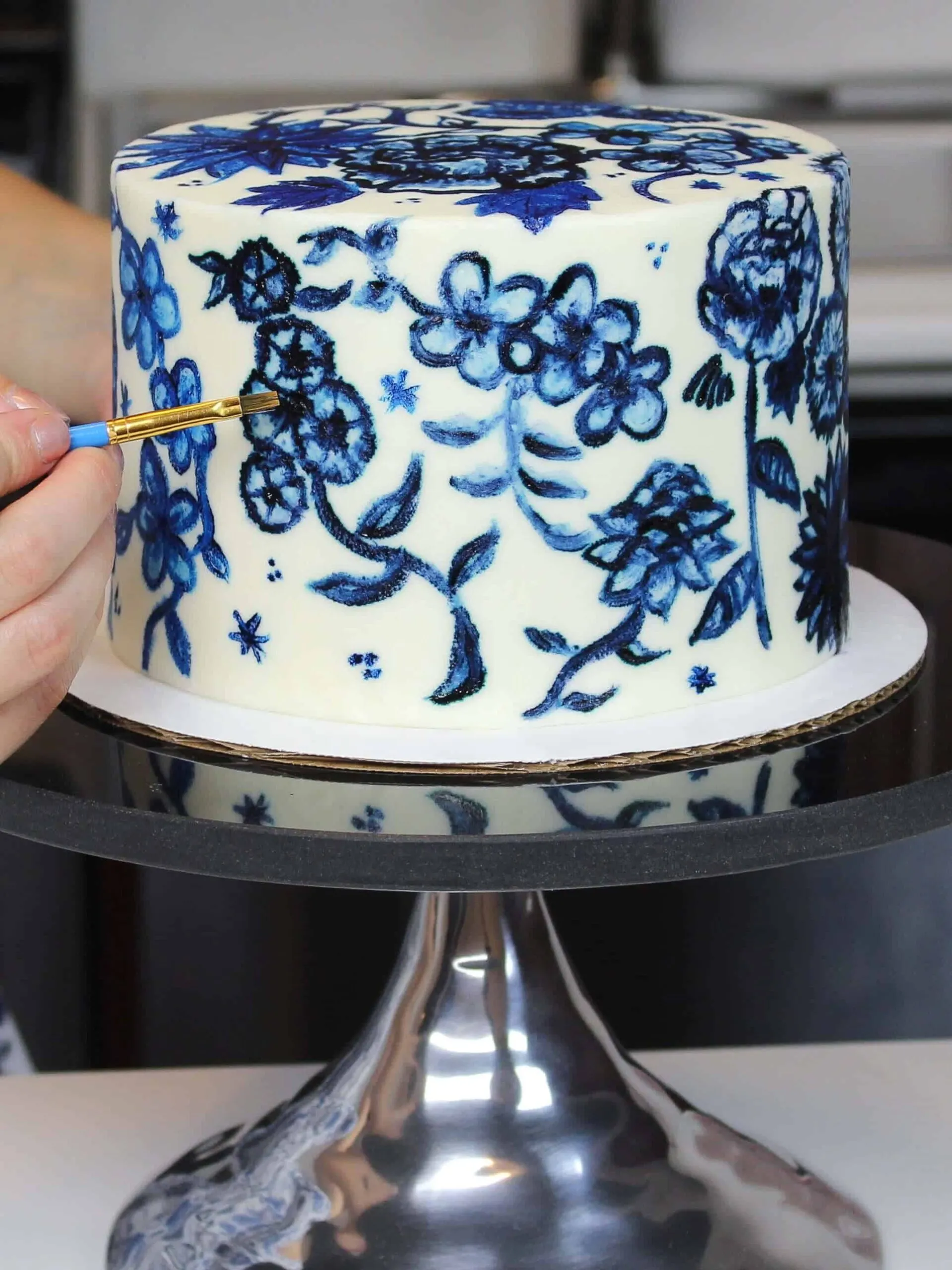 image of a buttercream cake being painted with edible paint made with gel food coloring and vodka
