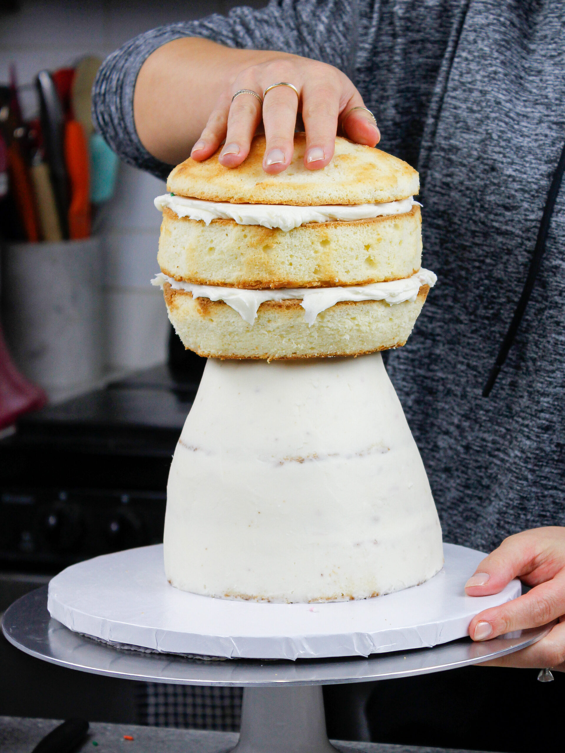 image of cake layers being stacked and frosted to make a polar bear cake