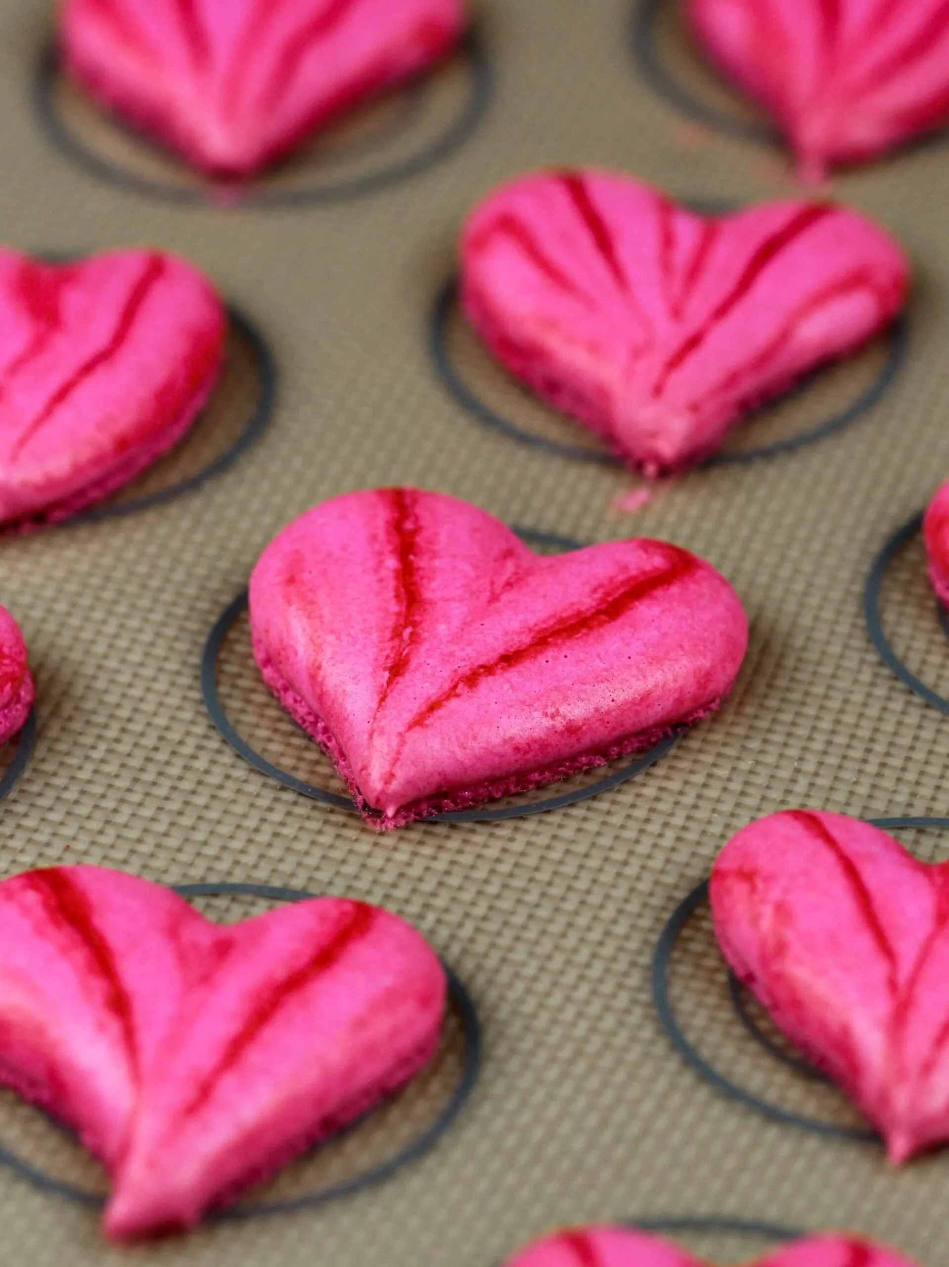 image of pretty pink heart shaped macarons that have been baked are are ready to be filled