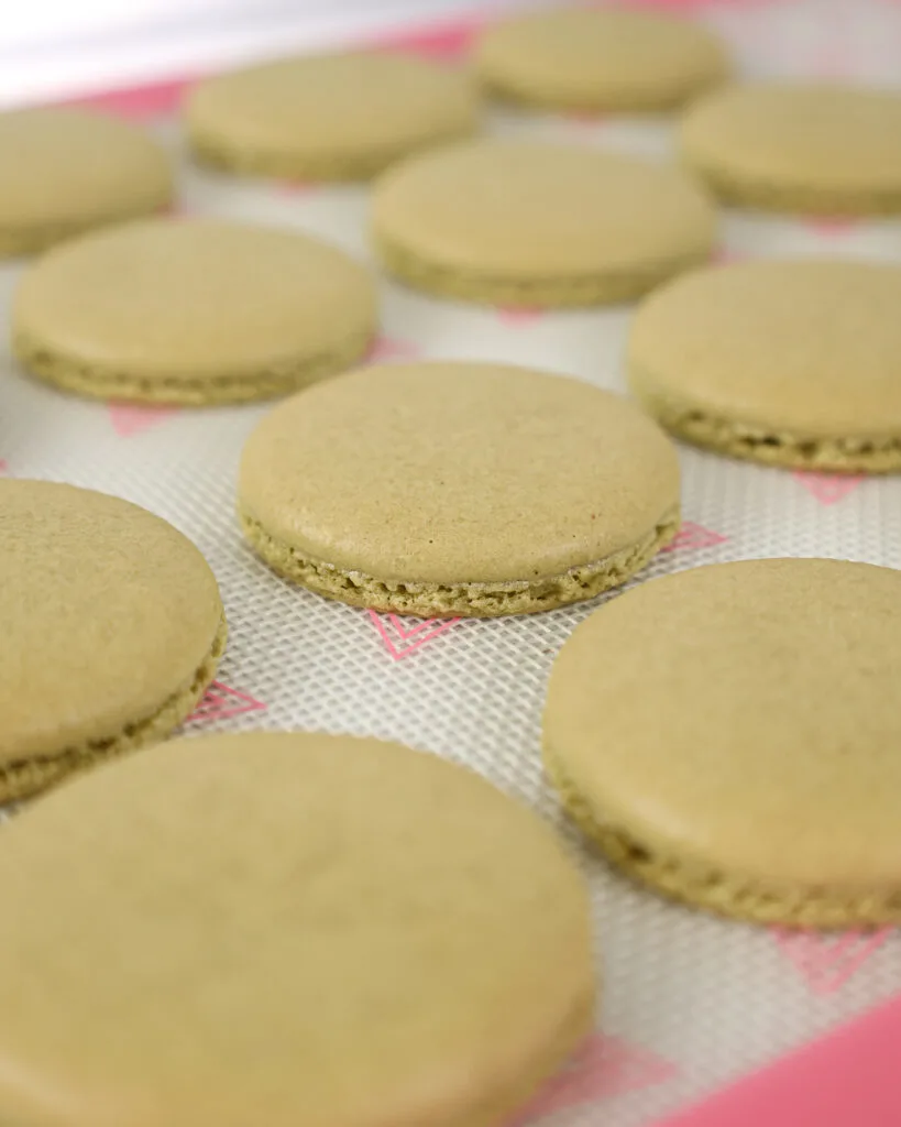 image of matcha macaron shells that have been baked and are cooling on the mat