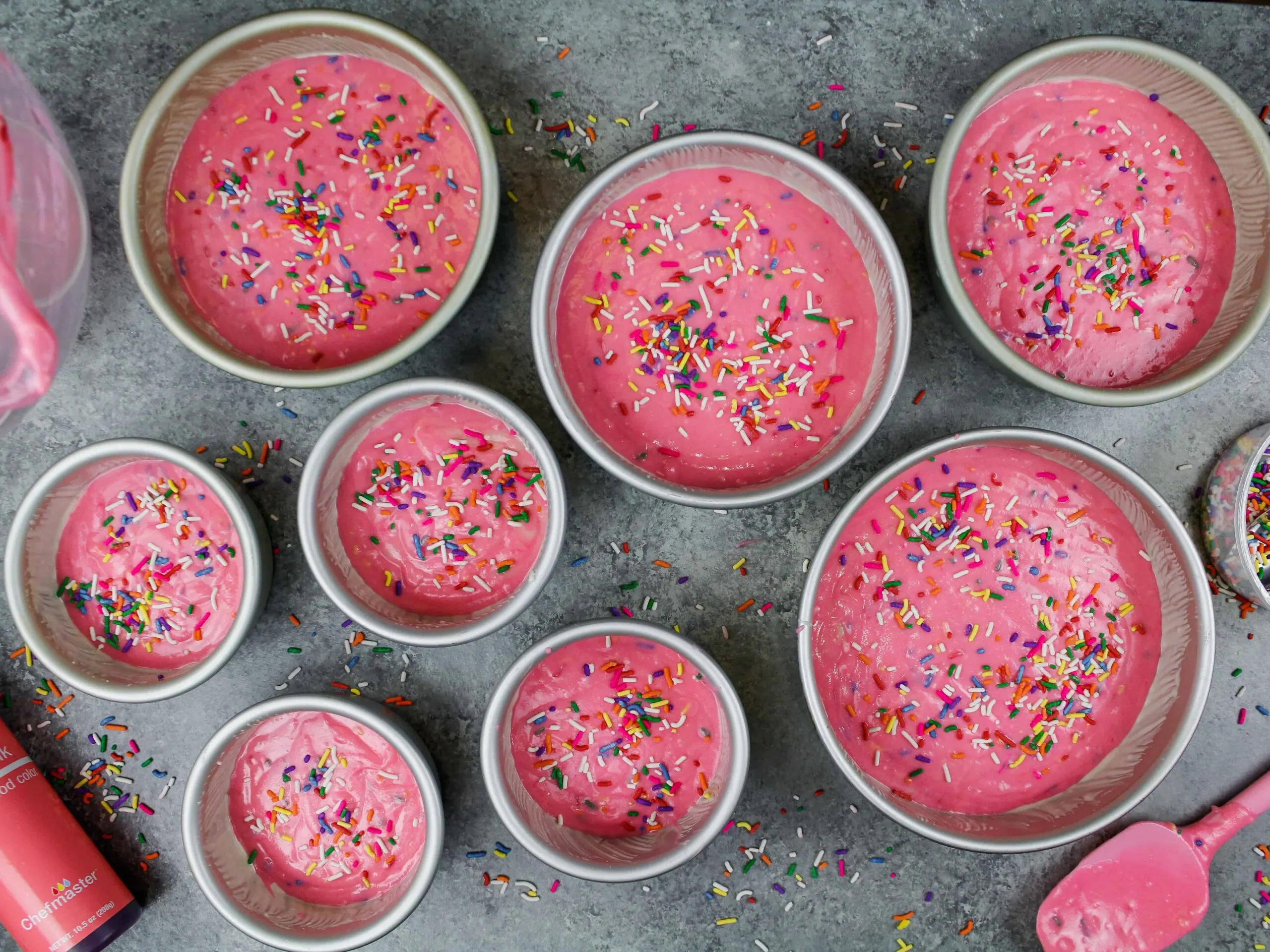 image of pink funfetti cake batter poured into pans and ready to be baked