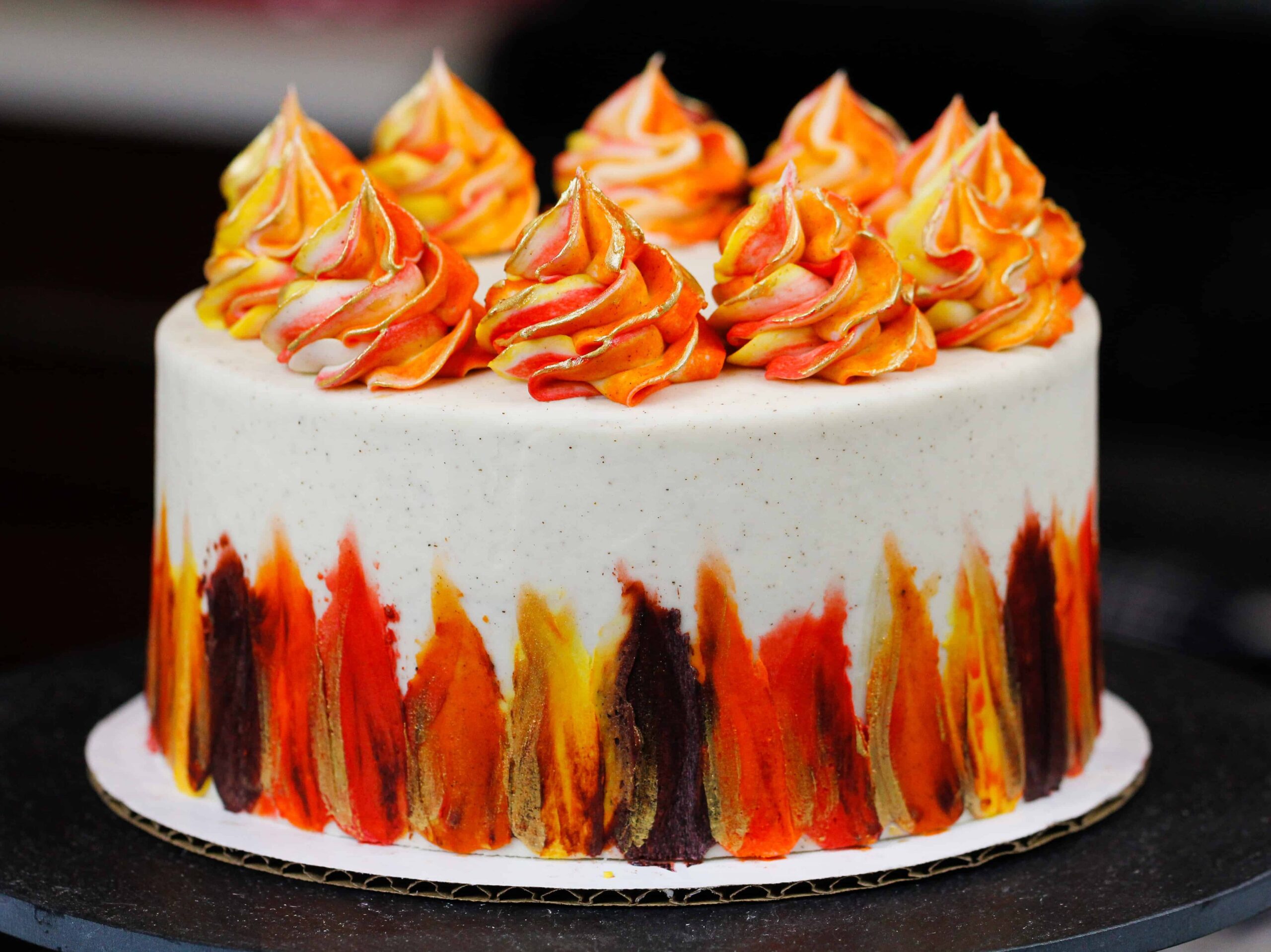 image of a layered spice cake frosted with a spiced cream cheese buttercream frosting and decorated with fall-inspired colors