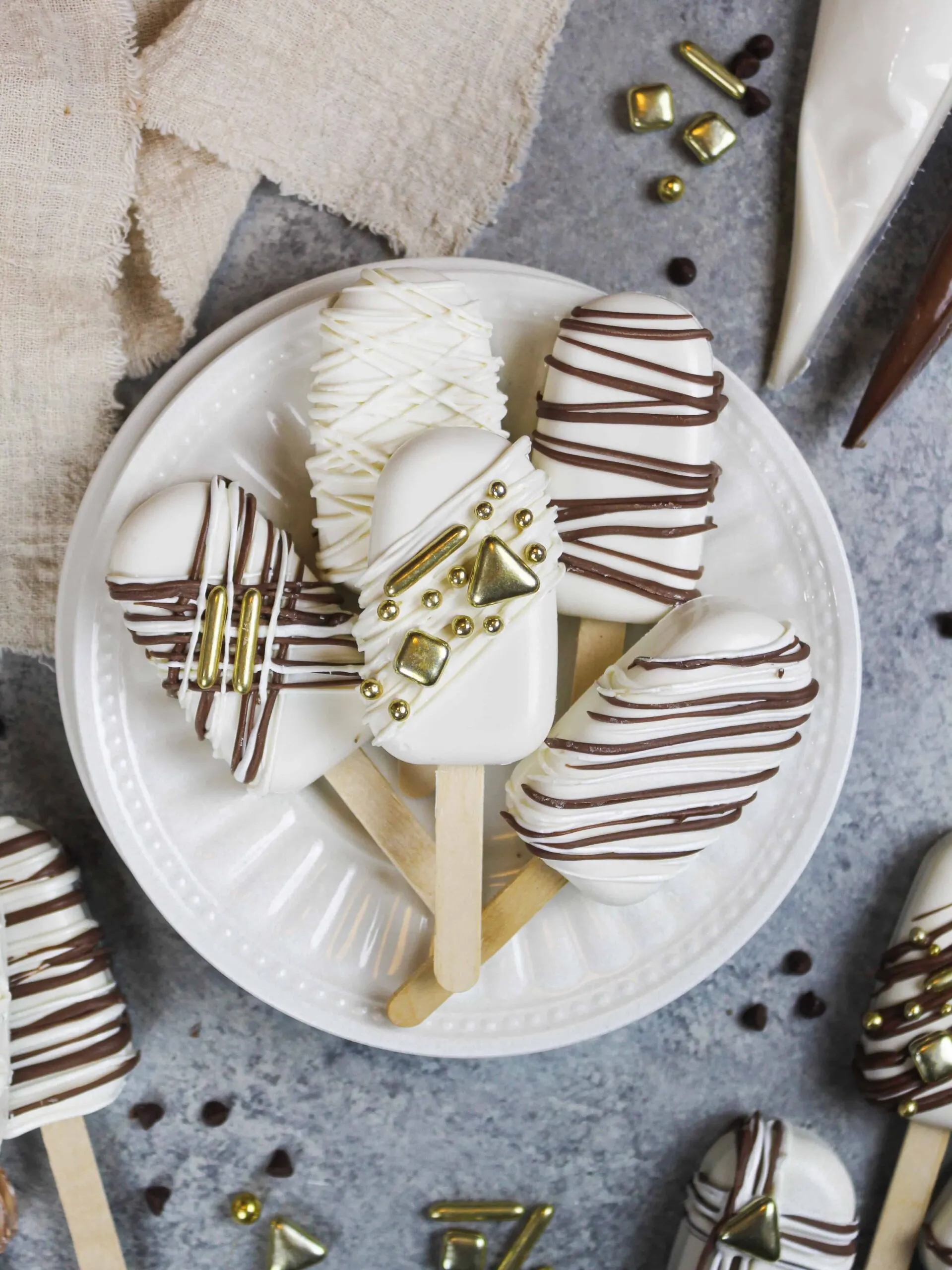 image of cakesicles decorated with white and dark chocolate drizzles