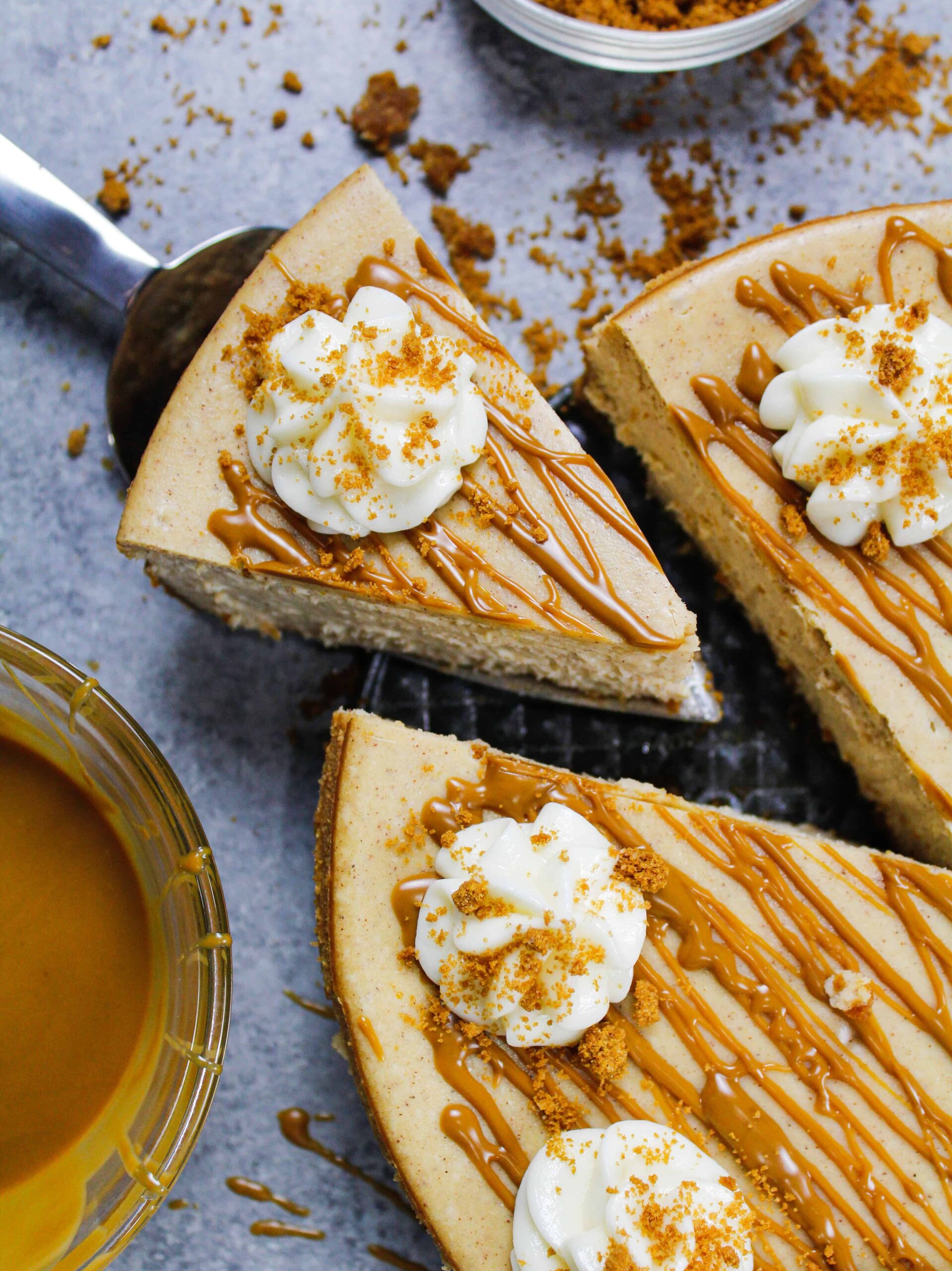 image of biscoff cheesecake that's been drizzled with warm cookie butter and topped with whipped cream