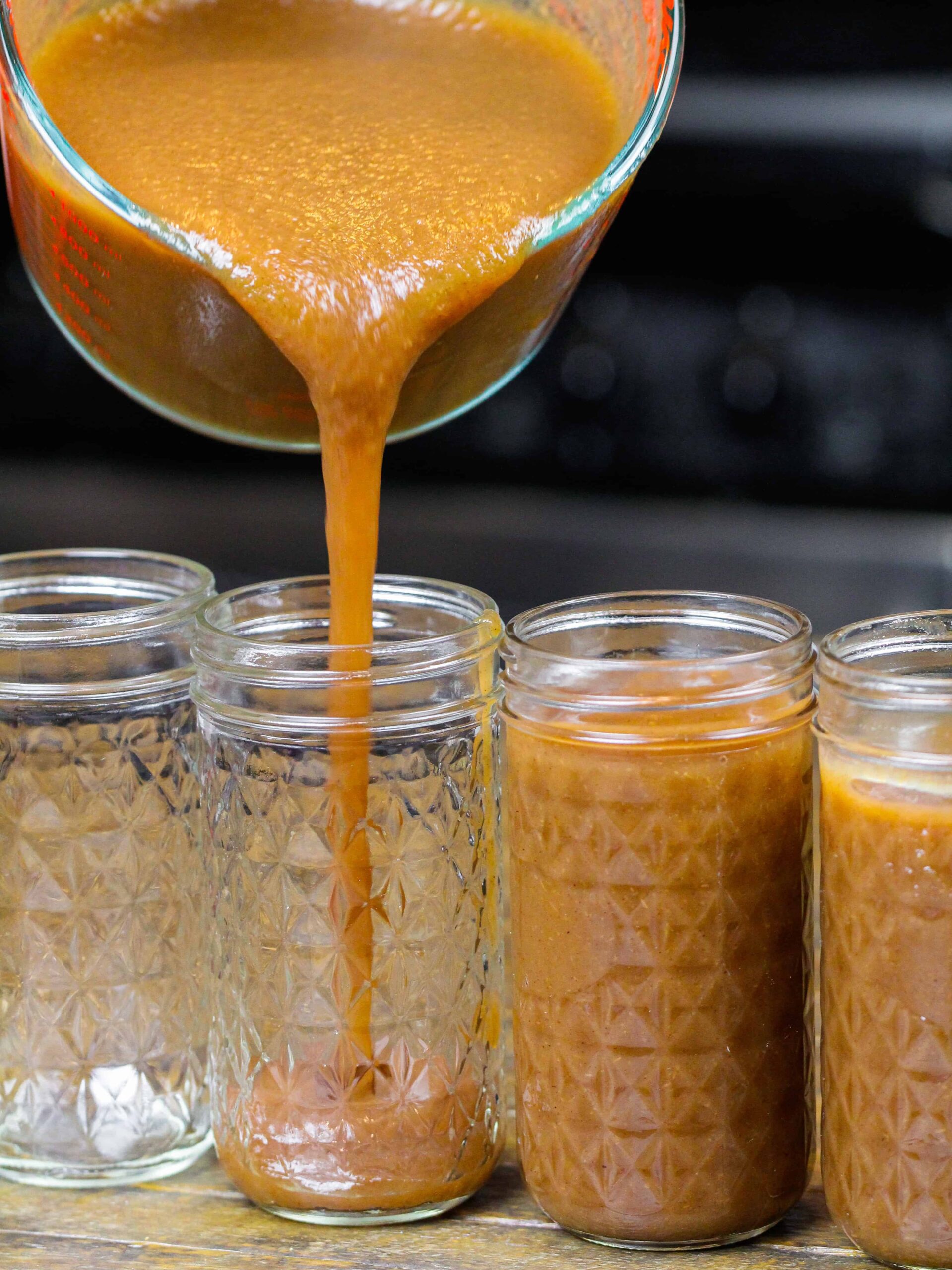 image of instant pot apple butter being poured into mason jars