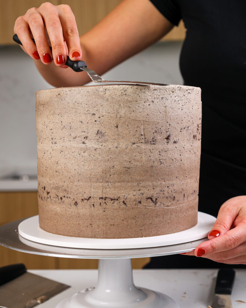 image of oreo frosting being smoothed onto an oreo brownie cake